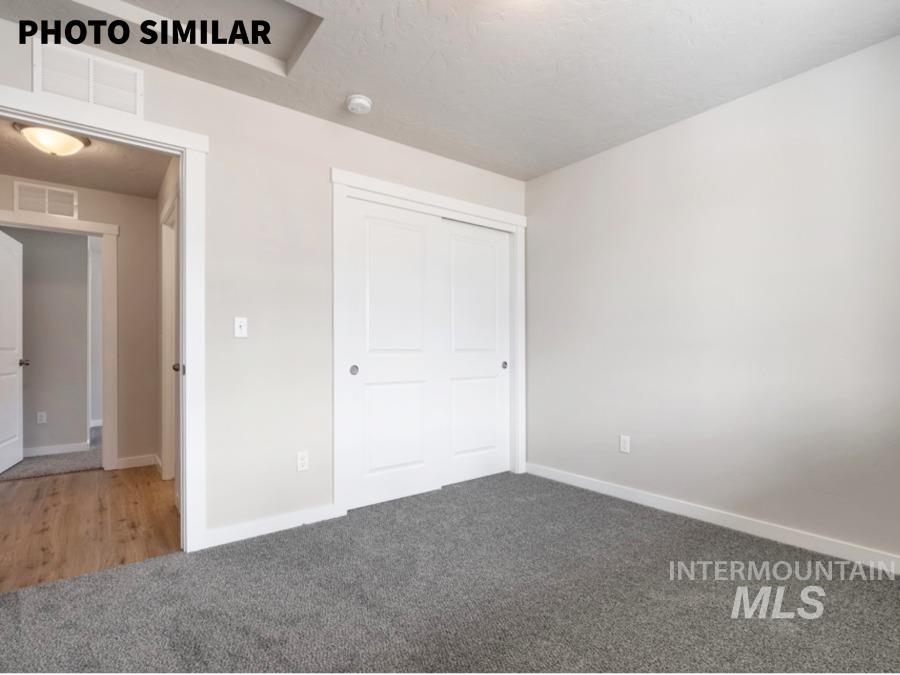 Neutral-toned room featuring gray carpeting and white trim