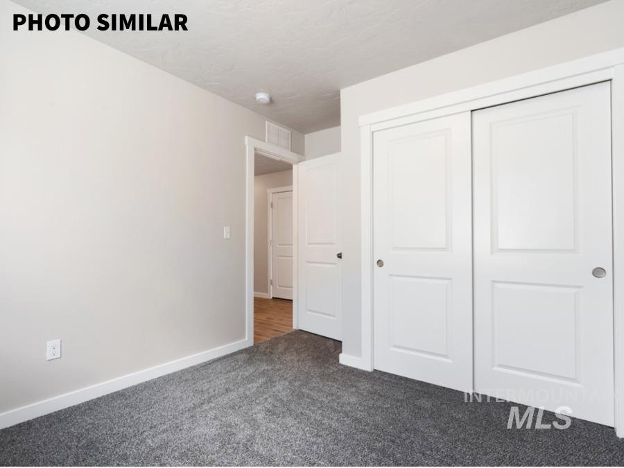 Bedroom featuring plush gray carpeting, white baseboards, and neutral wall paint