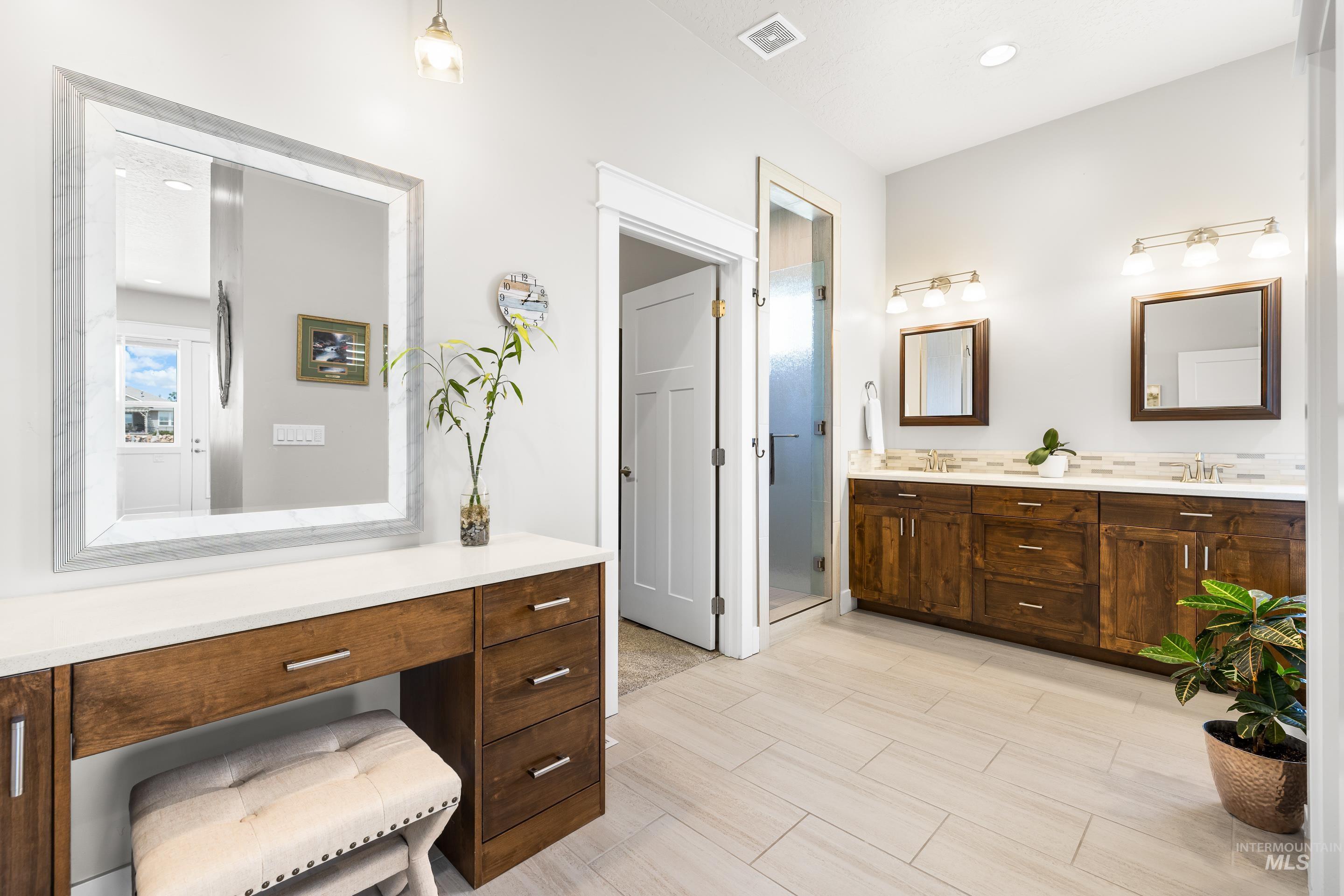 Bathroom with double vanity and a stall shower