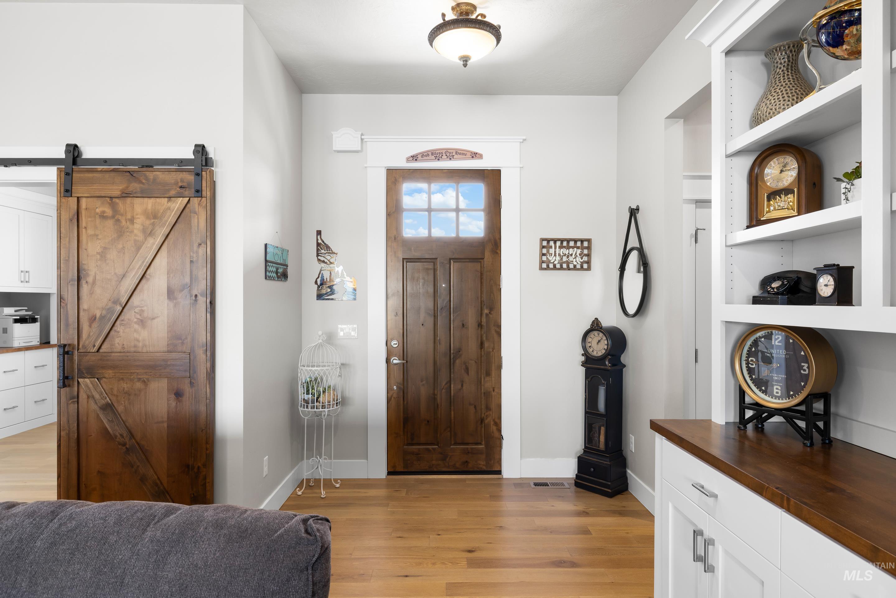 Foyer featuring light wood-style floors and a barn door