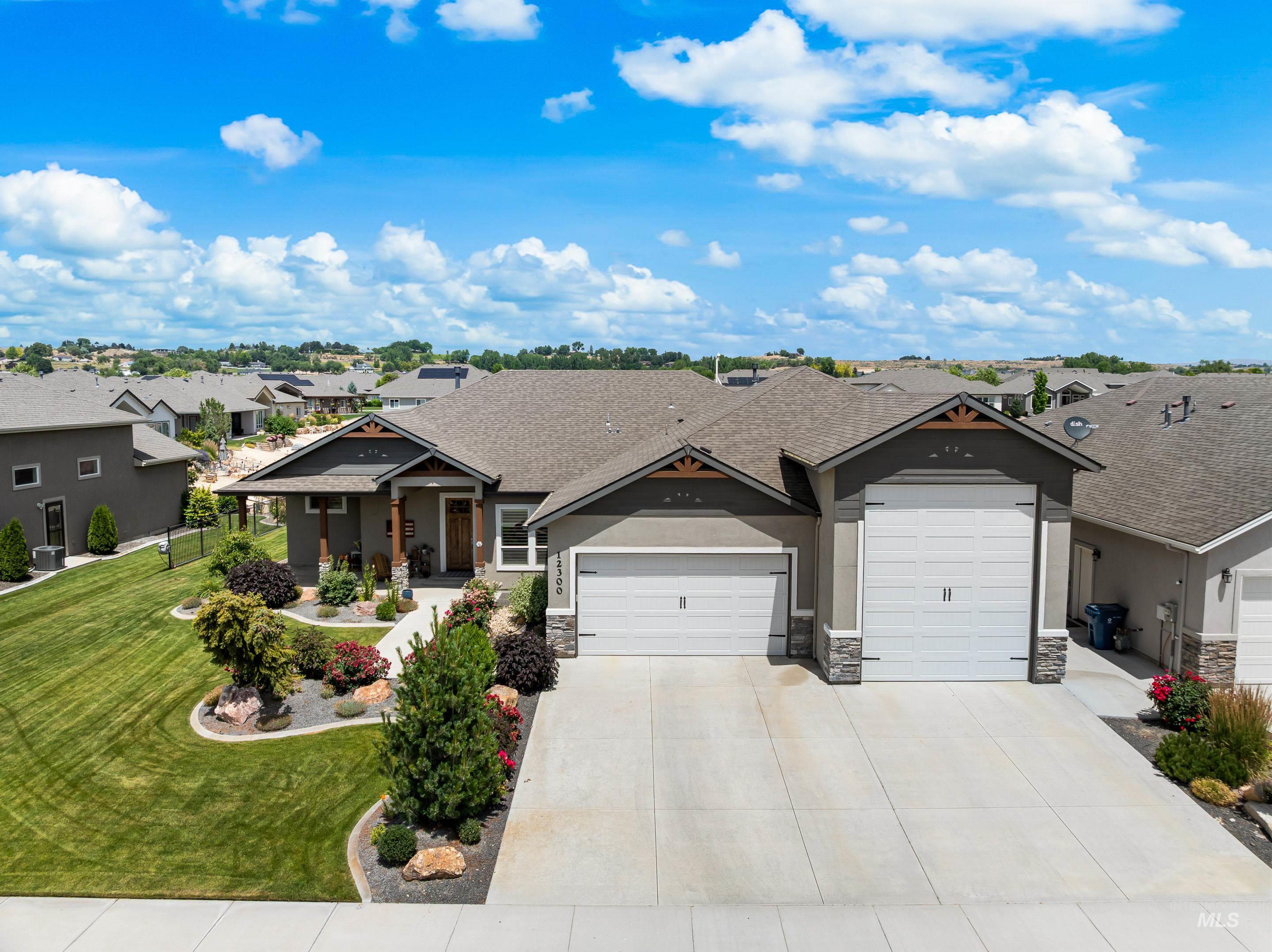 Craftsman-style house with a garage, a residential view, a front yard, and stone siding