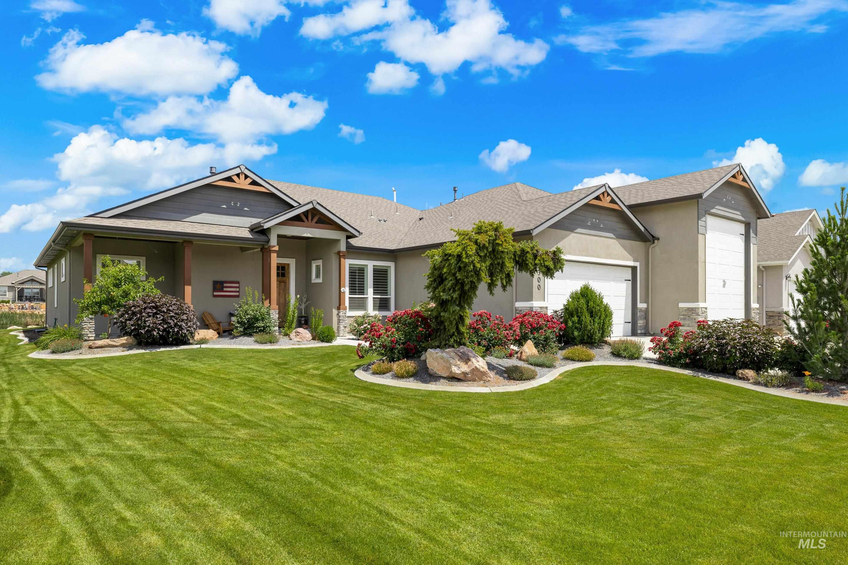 View of front facade with an attached garage, a front yard, stucco siding, and roof with shingles
