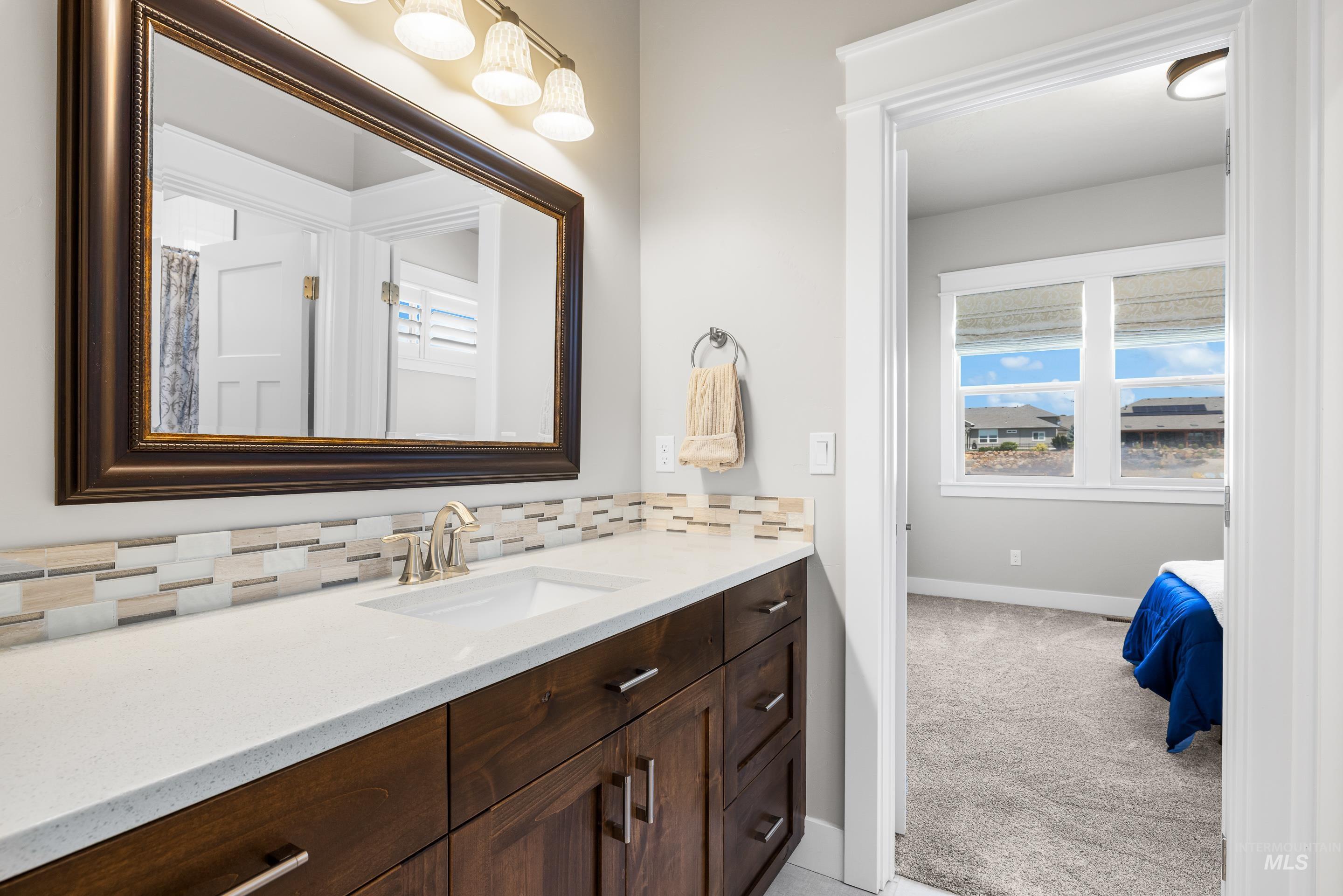 Bathroom featuring vanity and backsplash