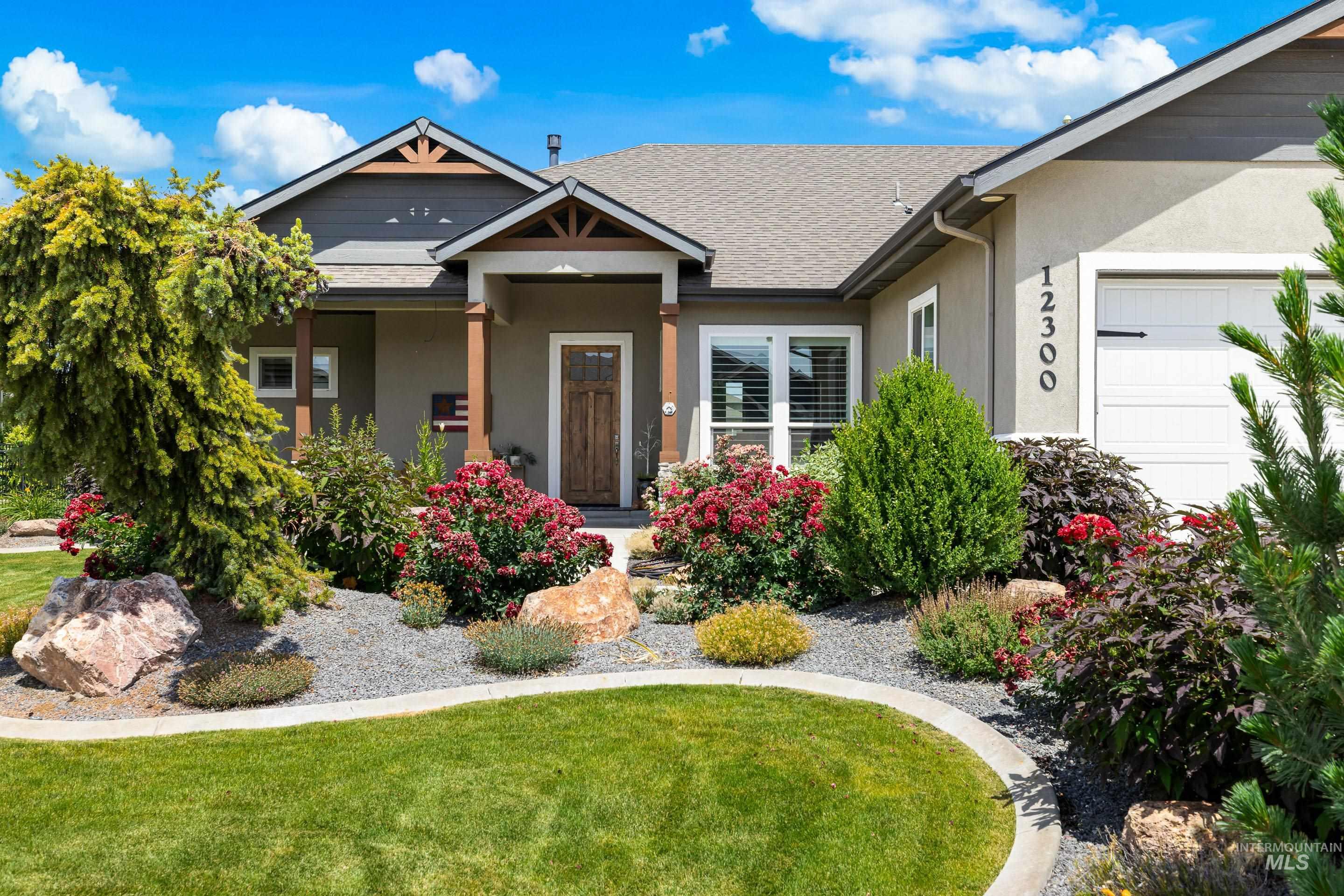 View of front of home with stucco siding, a front lawn, and a shingled roof