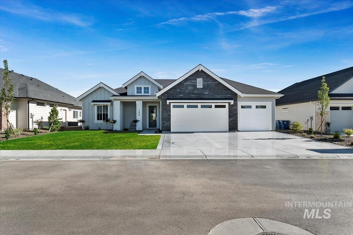 View of front of home with a front yard, a garage, board and batten siding, and concrete driveway
