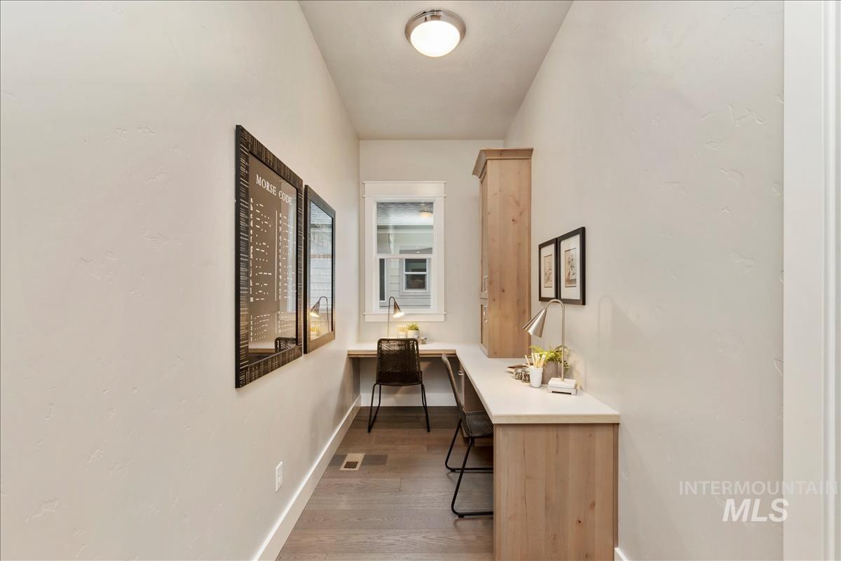Corridor with light wood-style flooring and a desk