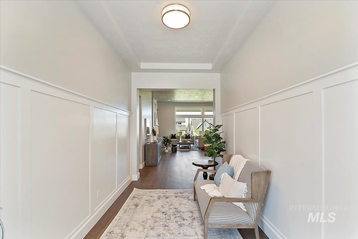 Hallway with a decorative wall and dark wood-type flooring