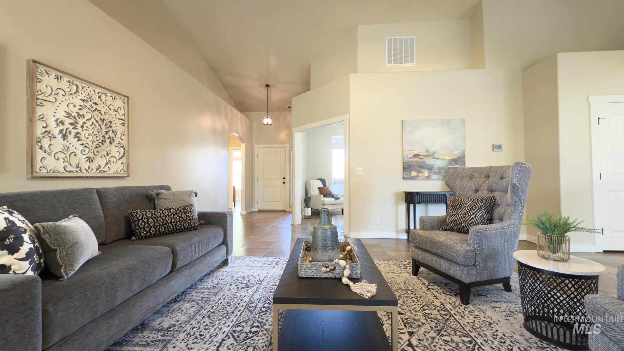 Living room featuring arched walkways and tile patterned flooring