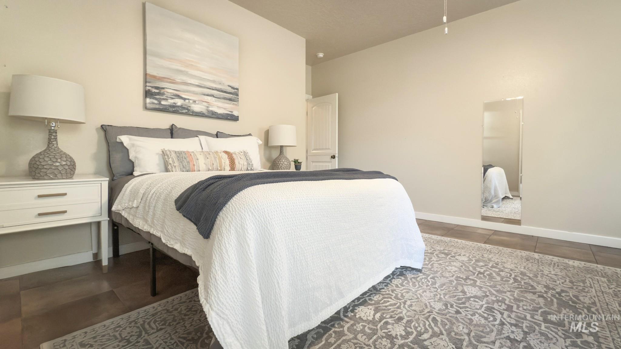 Bedroom featuring dark tile patterned floors and baseboards