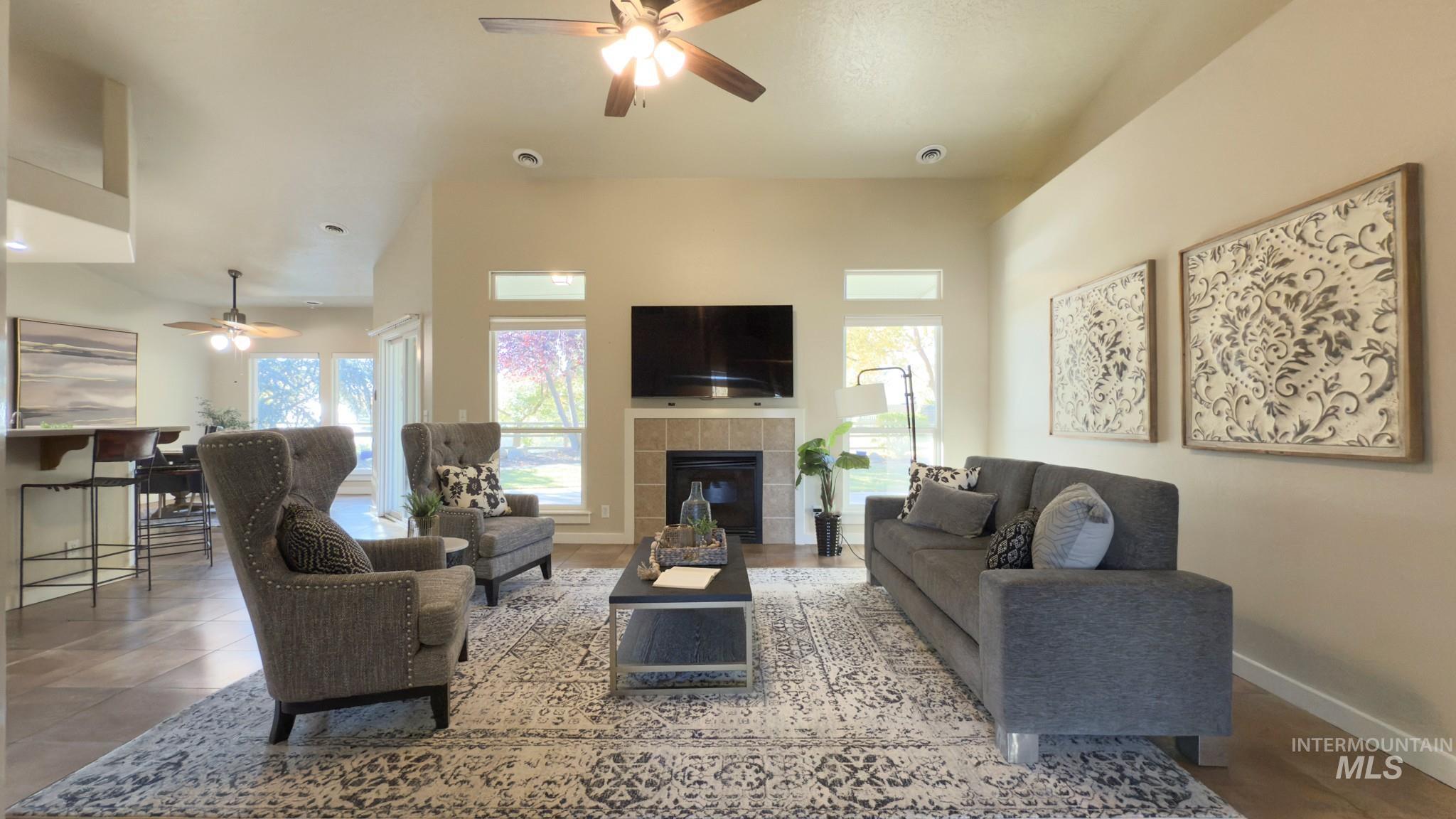Living area with ceiling fan and a fireplace