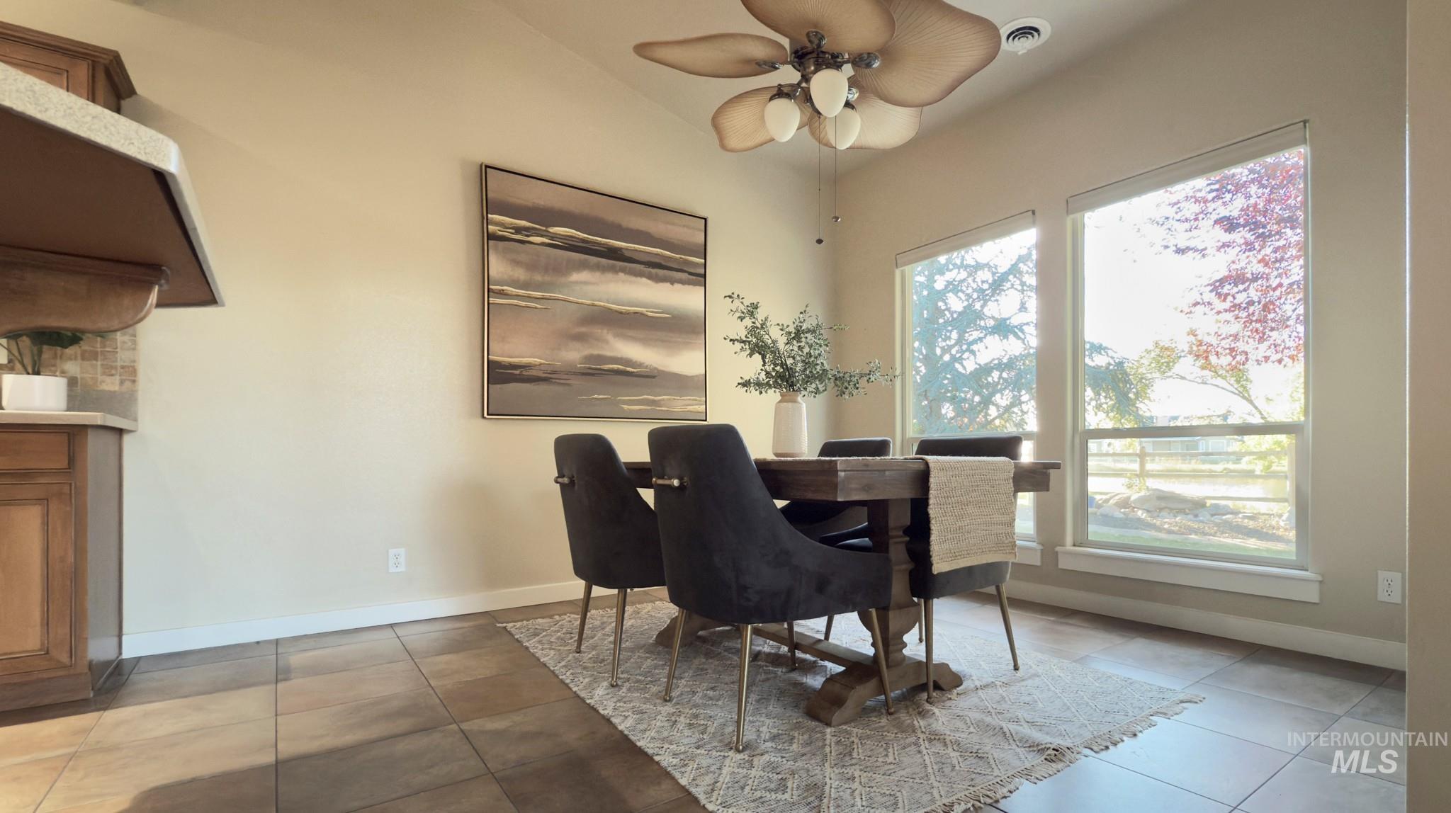 Dining area featuring light tile patterned flooring and a ceiling fan