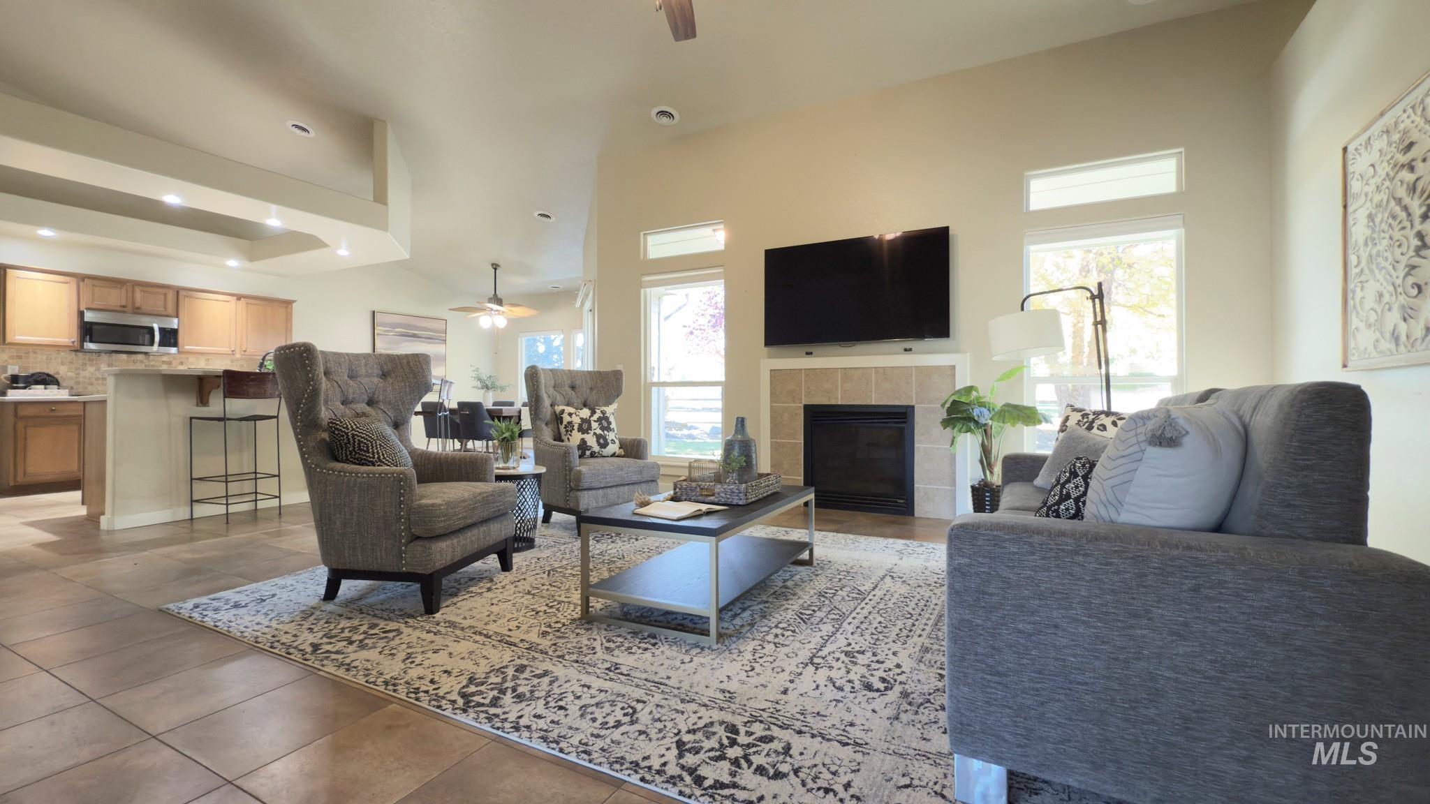 Living area with ceiling fan, a tile fireplace, healthy amount of natural light, recessed lighting, and light tile patterned floors