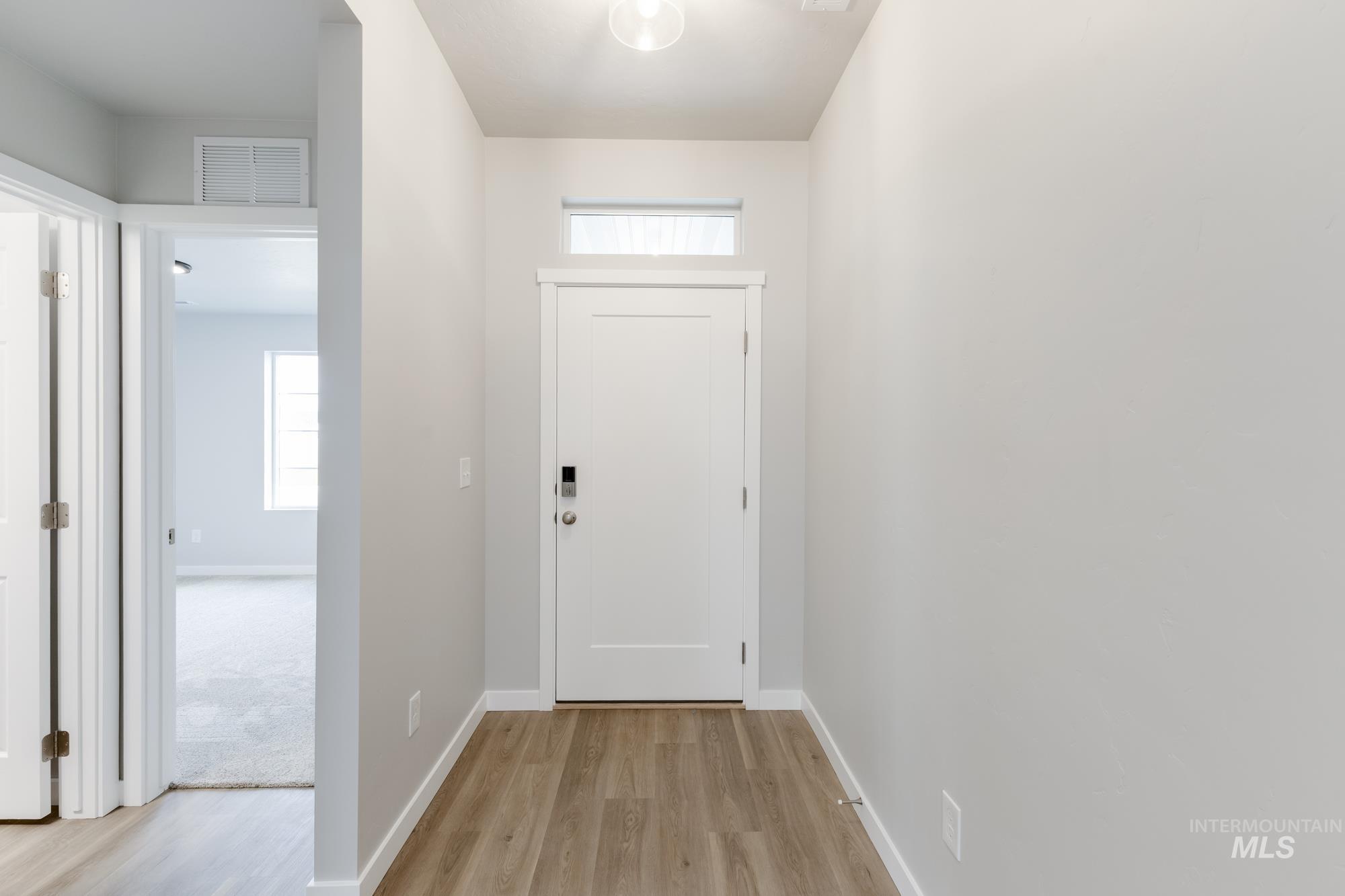 Doorway to outside featuring baseboards and wood finished floors
