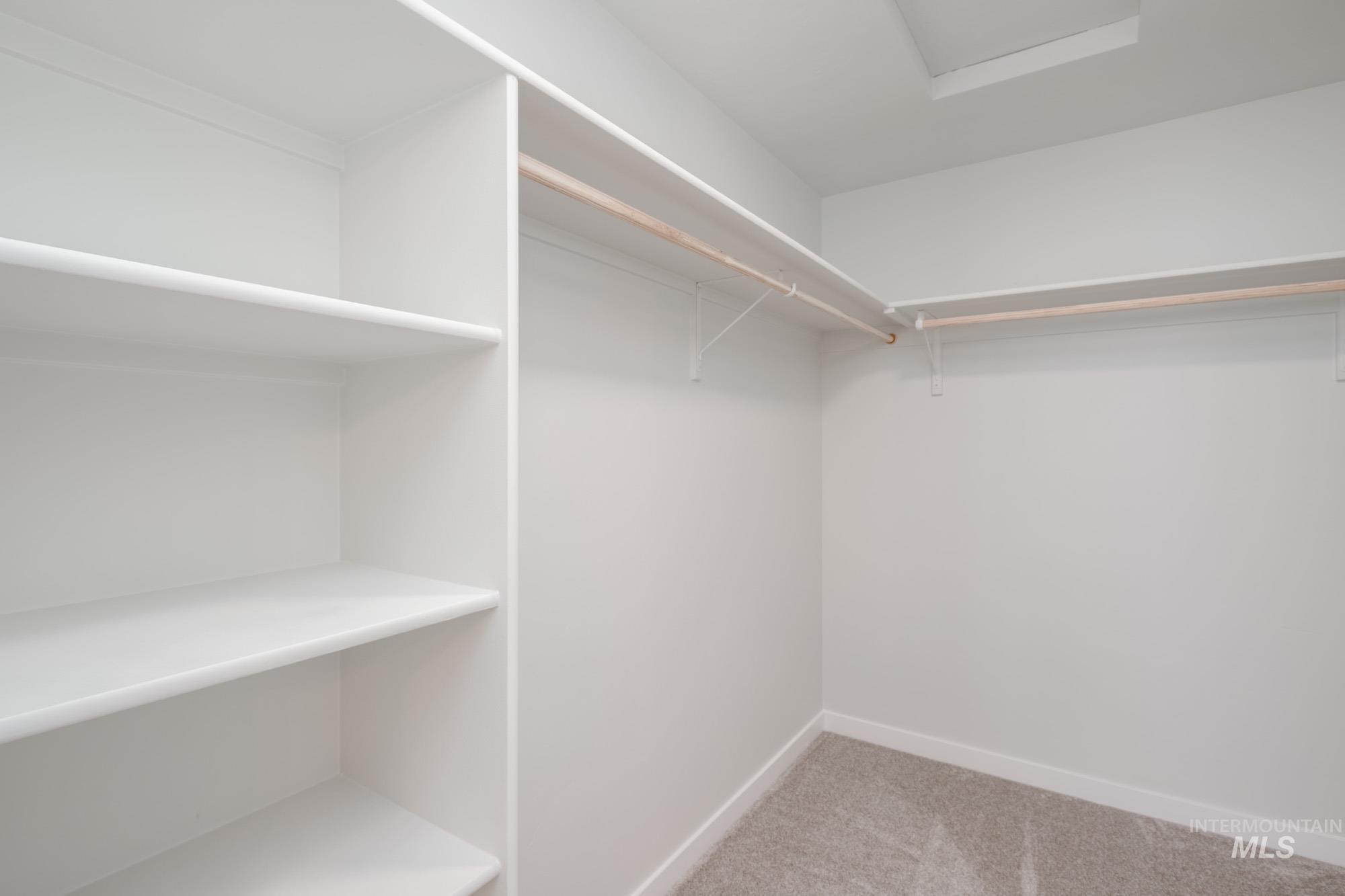 Spacious closet with light colored carpet