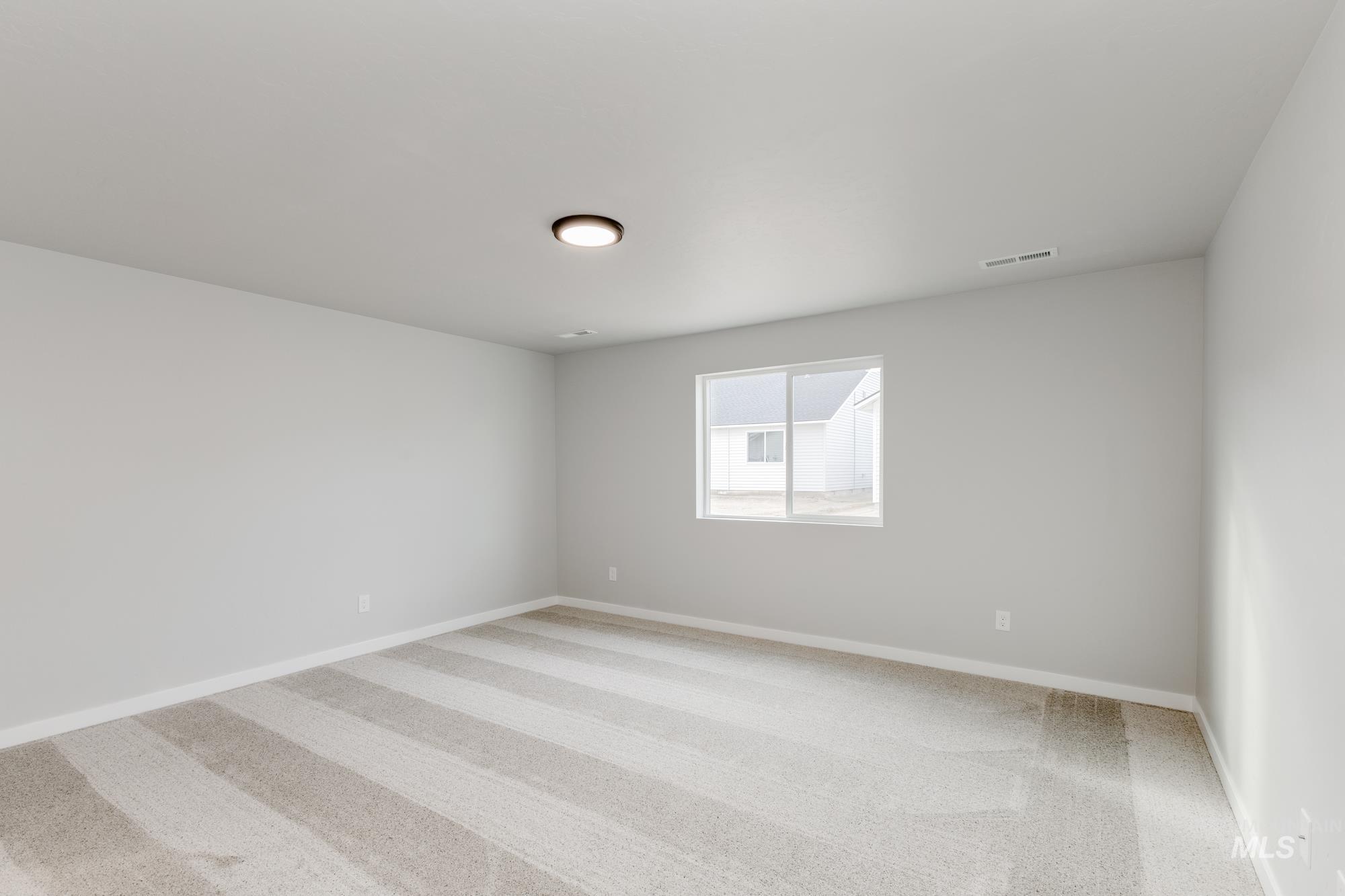 Unfurnished room featuring light carpet and baseboards