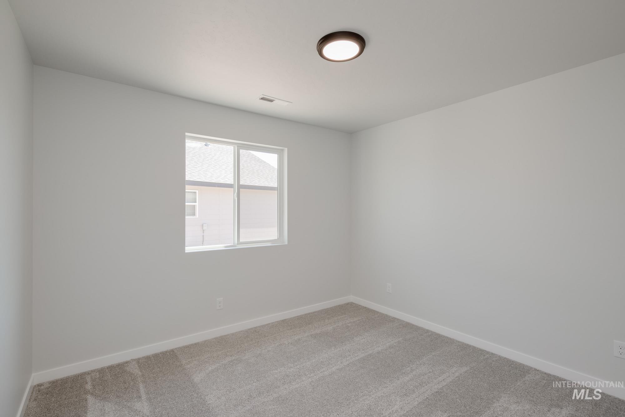 Carpeted empty room featuring baseboards
