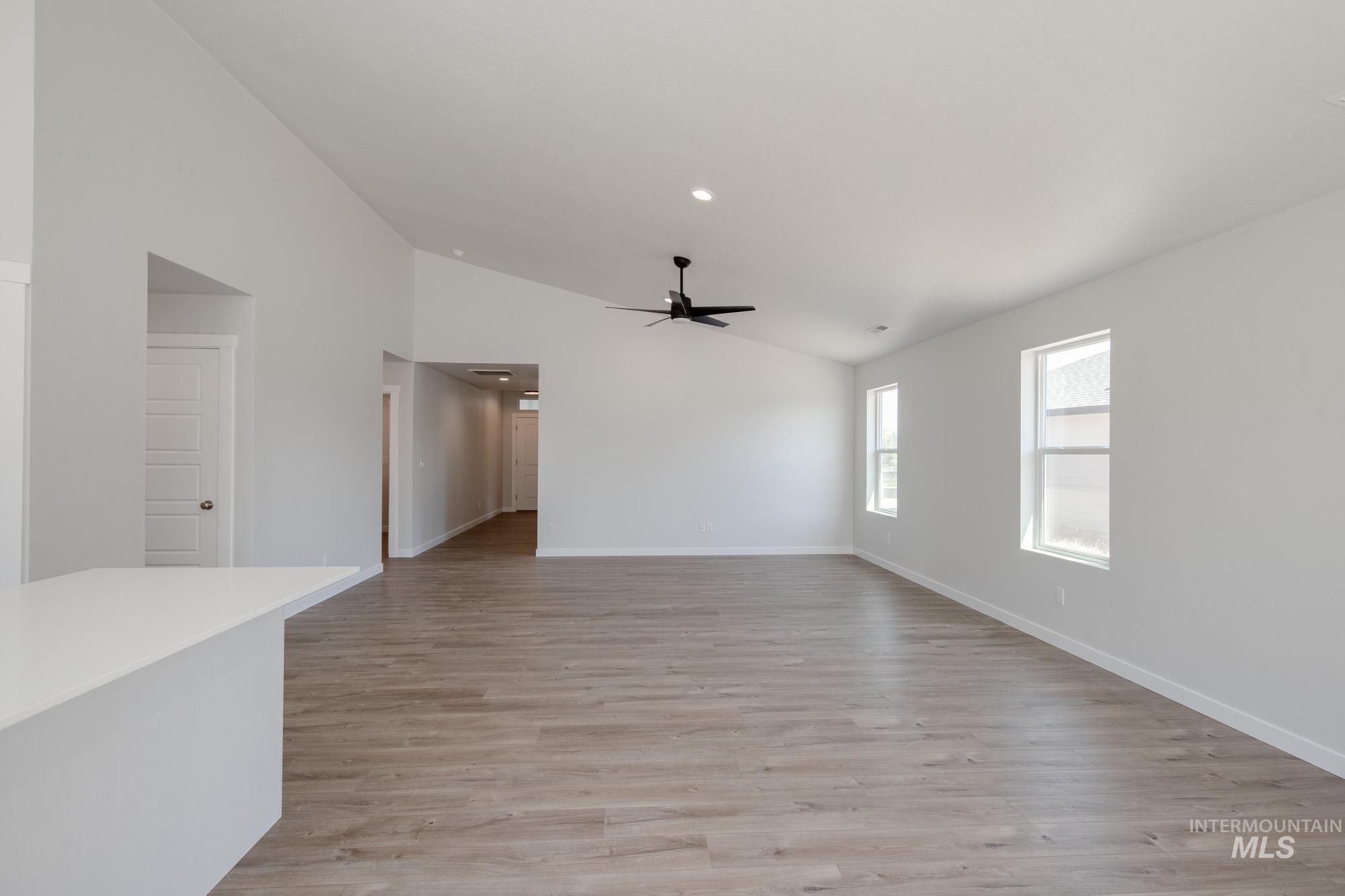 Spare room featuring light wood-style floors, lofted ceiling, recessed lighting, and a ceiling fan