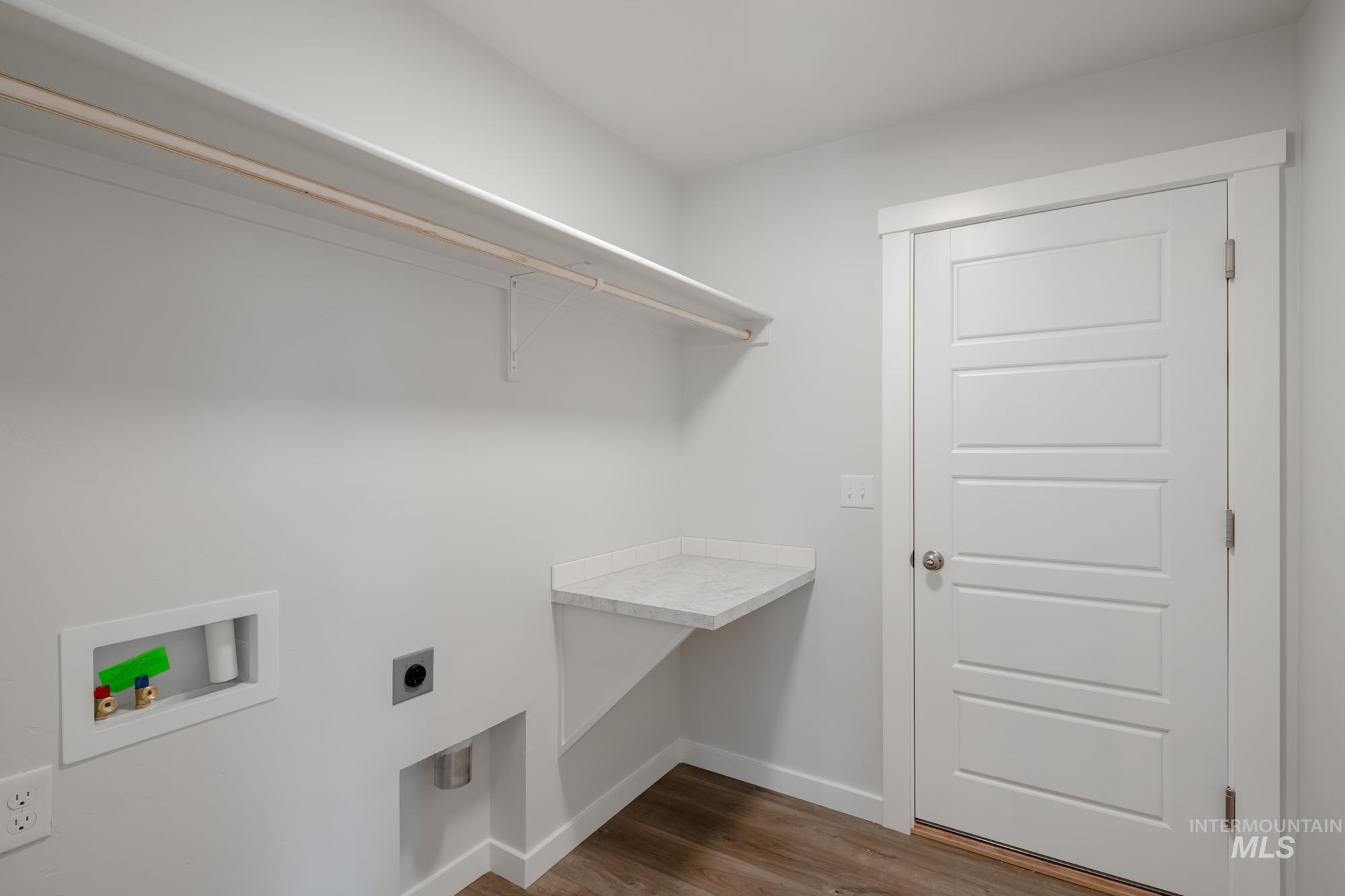 Washroom with dark wood-style flooring, electric dryer hookup, and hookup for a washing machine
