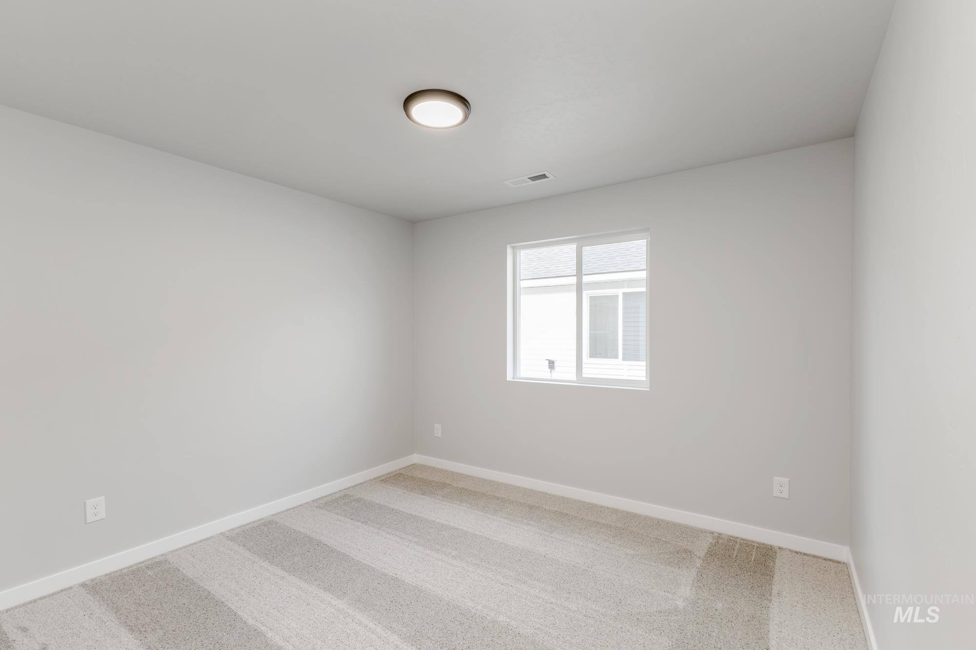 Carpeted spare room with baseboards