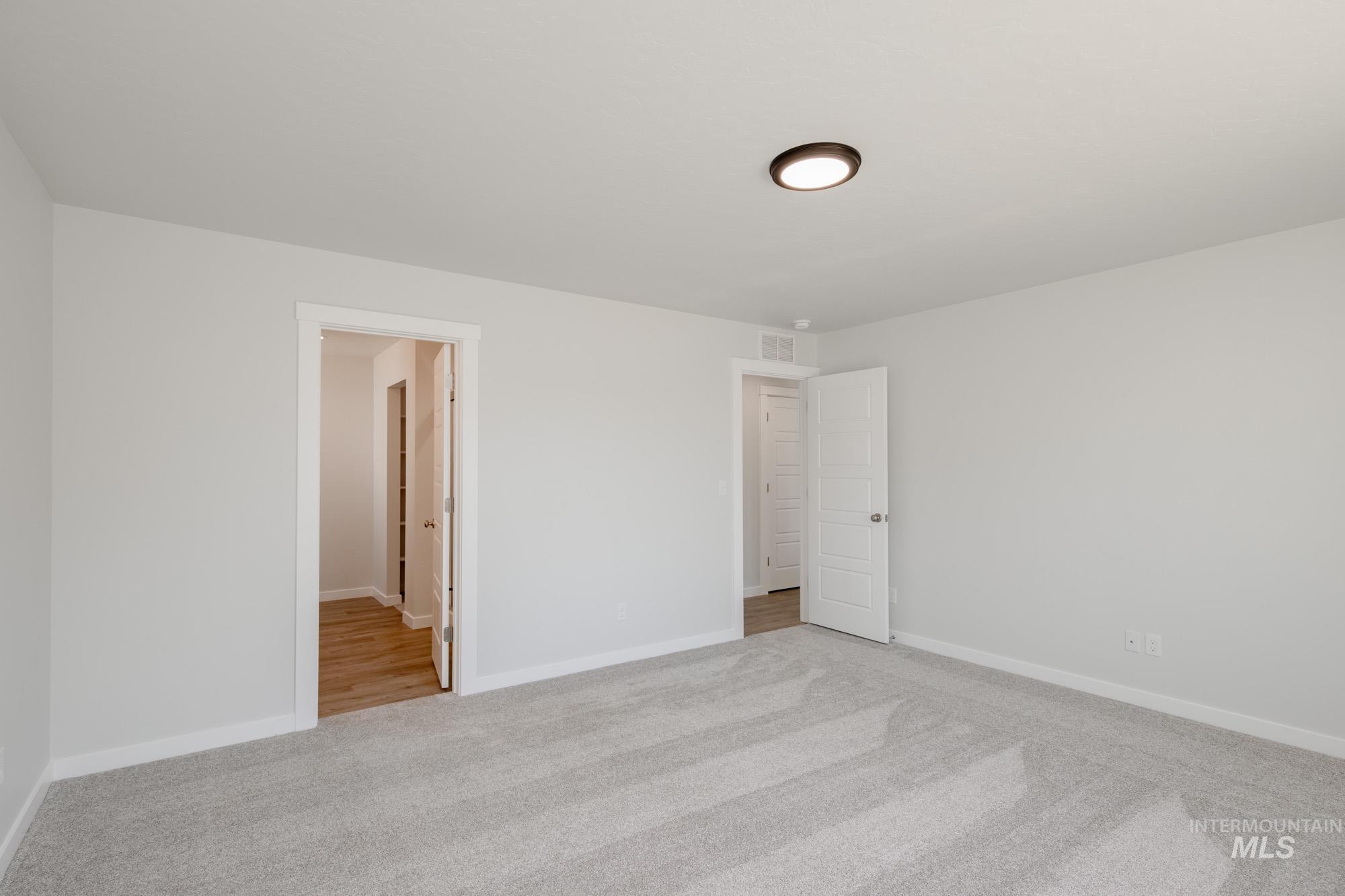 Unfurnished bedroom featuring light colored carpet and baseboards