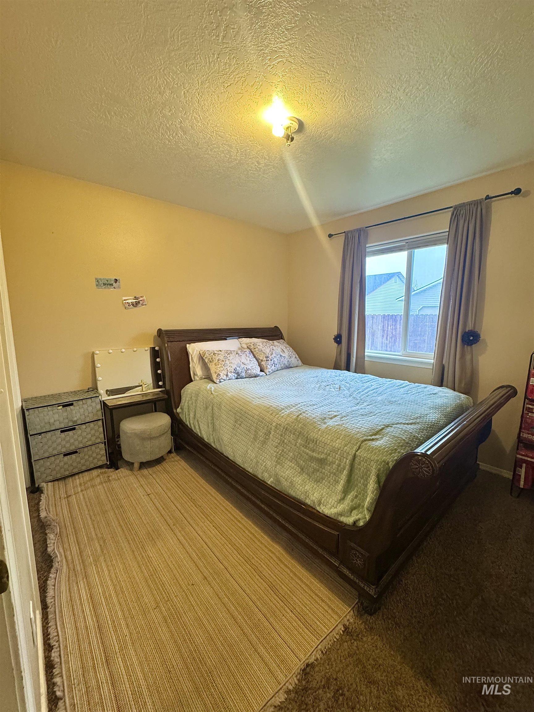 Carpeted bedroom with a textured ceiling