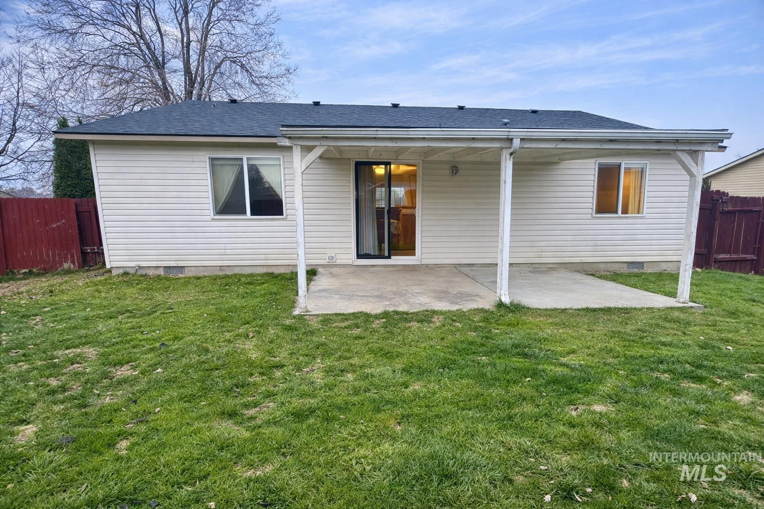 Rear view of house featuring a shingled roof, a patio area, and crawl space