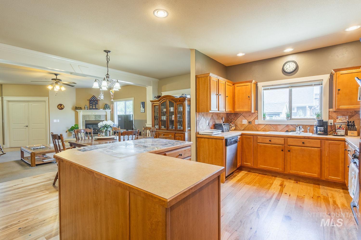 Kitchen with decorative backsplash, plenty of natural light, a center island, light wood finished floors, and recessed lighting