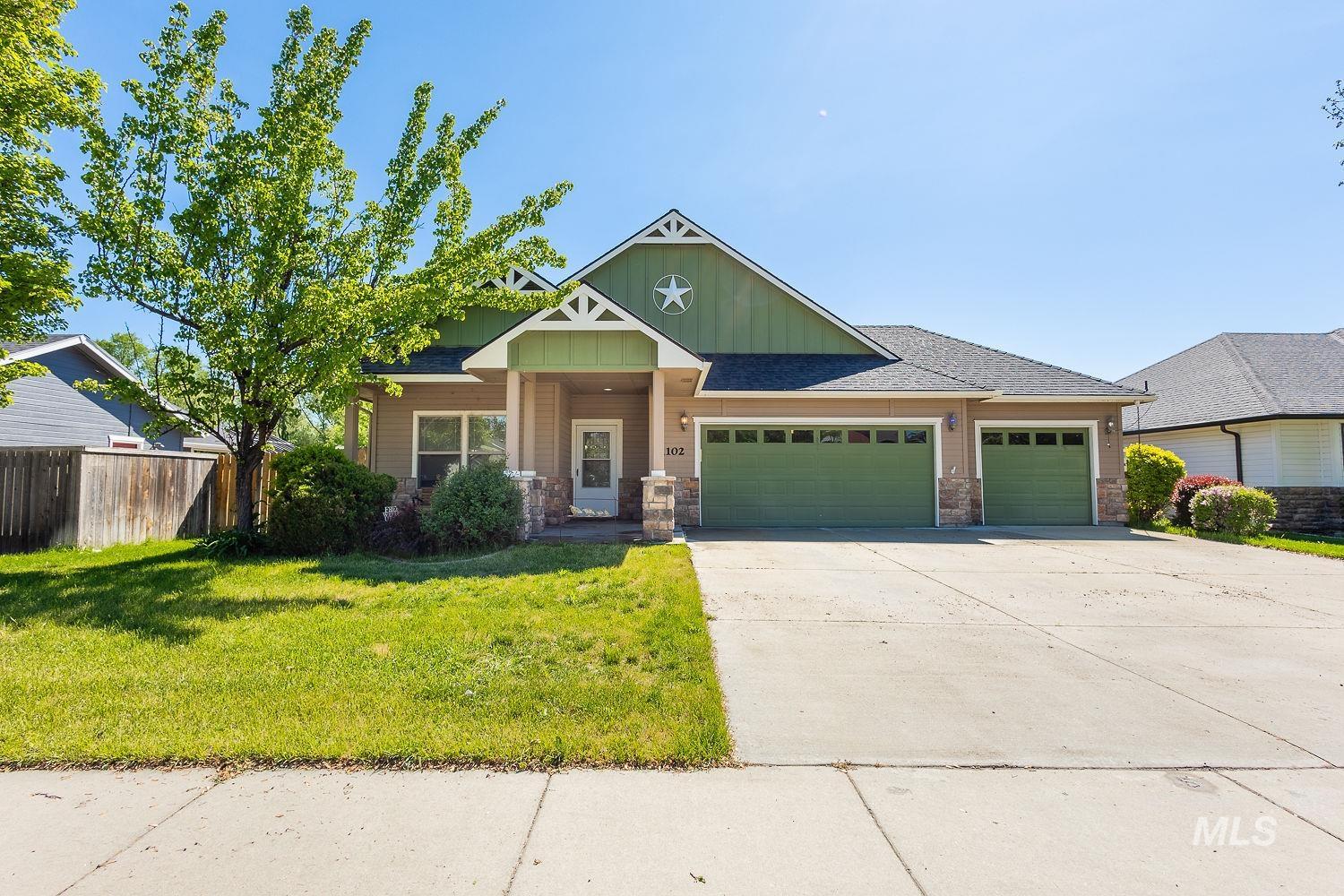 Craftsman-style house featuring an attached garage, concrete driveway, board and batten siding, stone siding, and roof with shingles