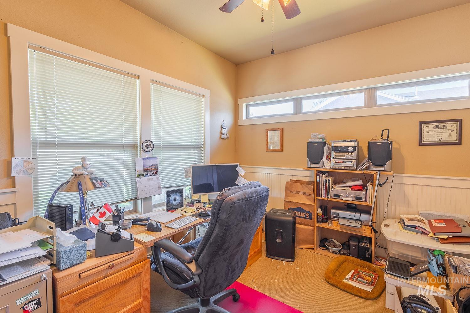 Office featuring a wainscoted wall and a ceiling fan