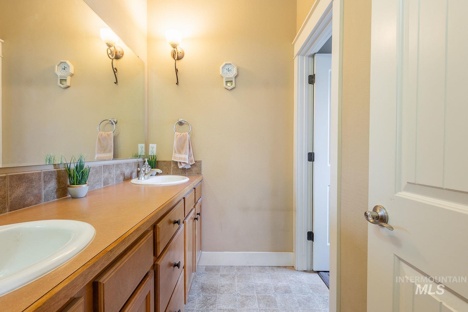 Full bath with double vanity and baseboards