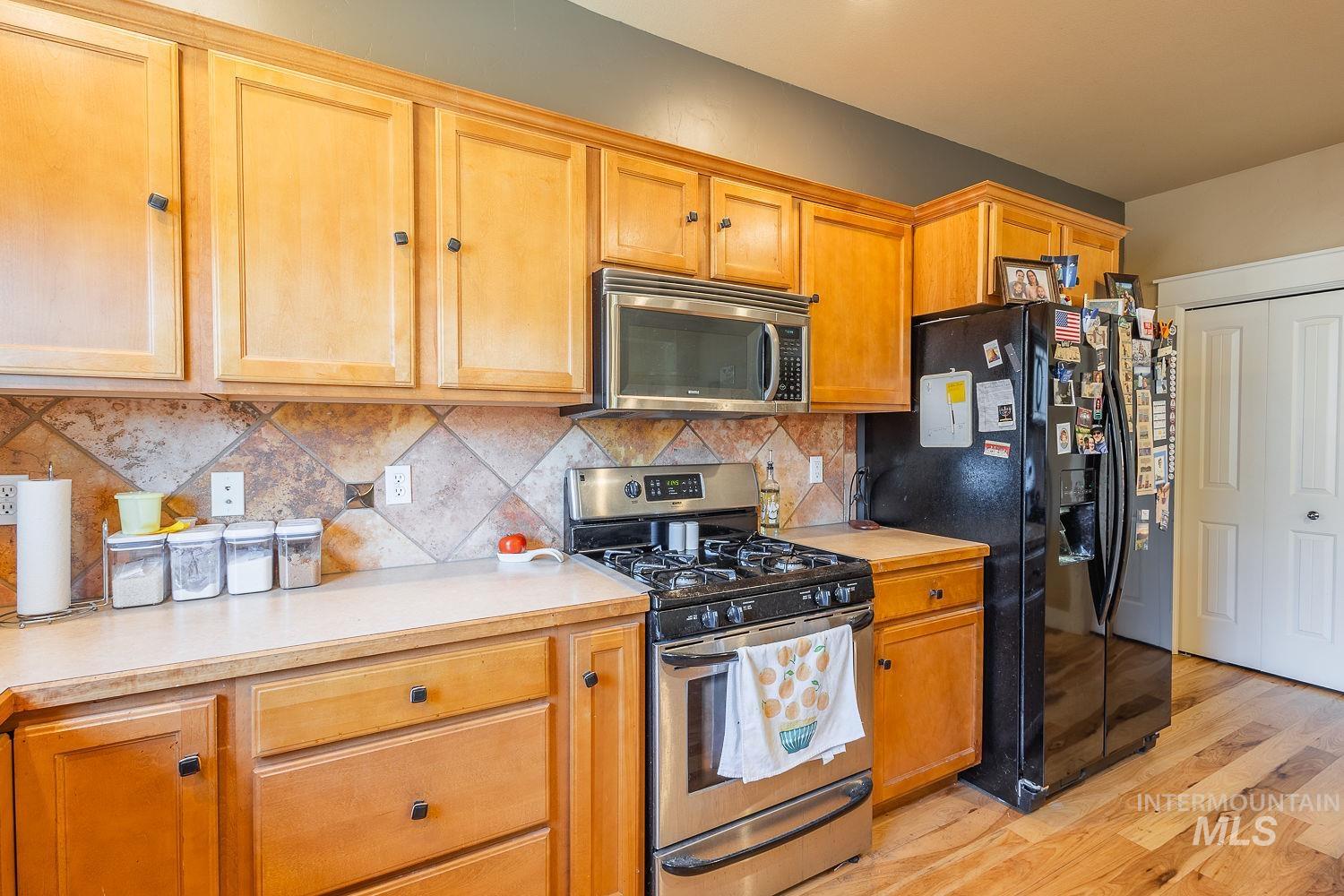 Kitchen featuring appliances with stainless steel finishes, light countertops, and light wood-style floors