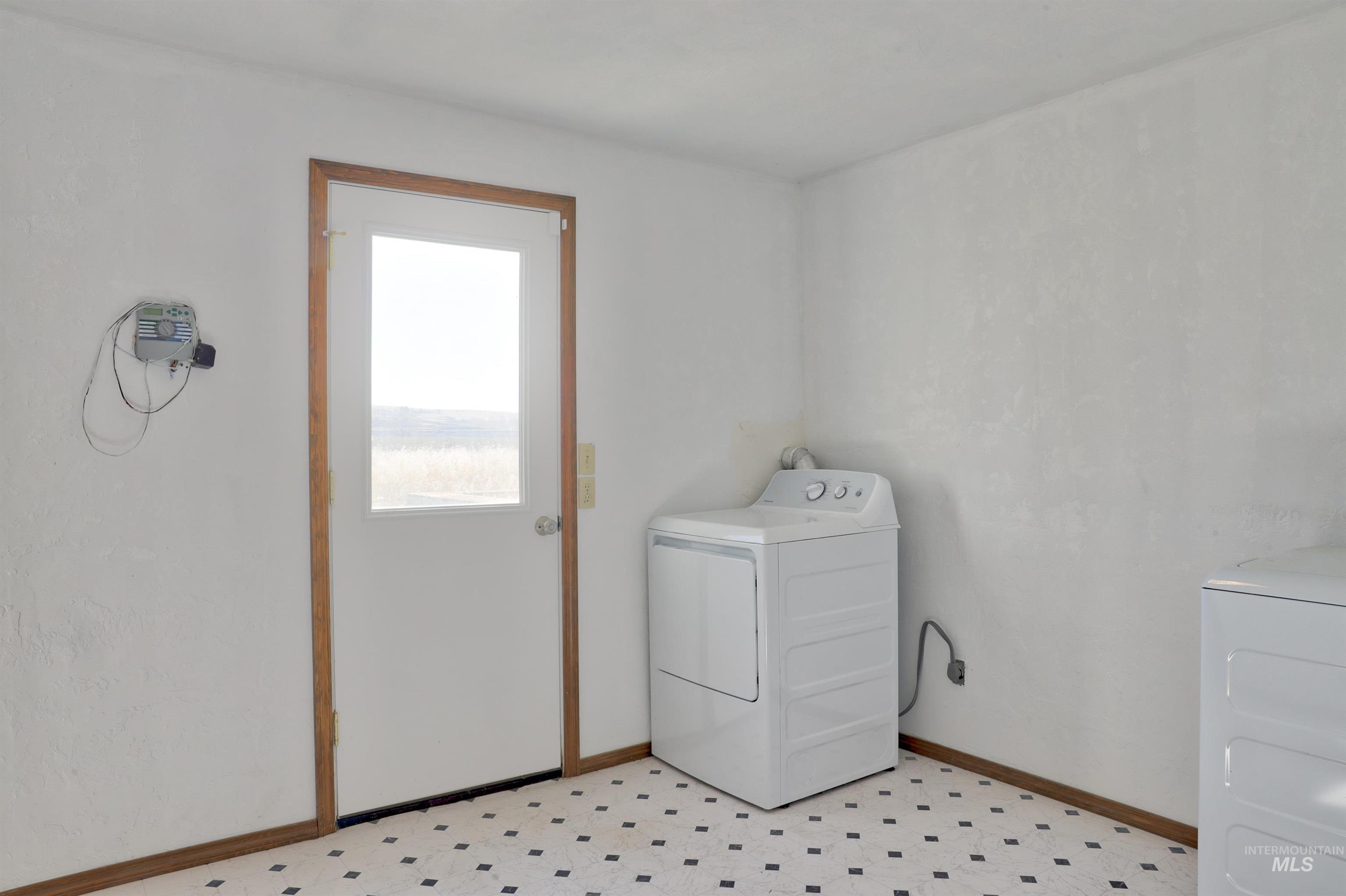 Laundry area with light floors and washing machine and clothes dryer