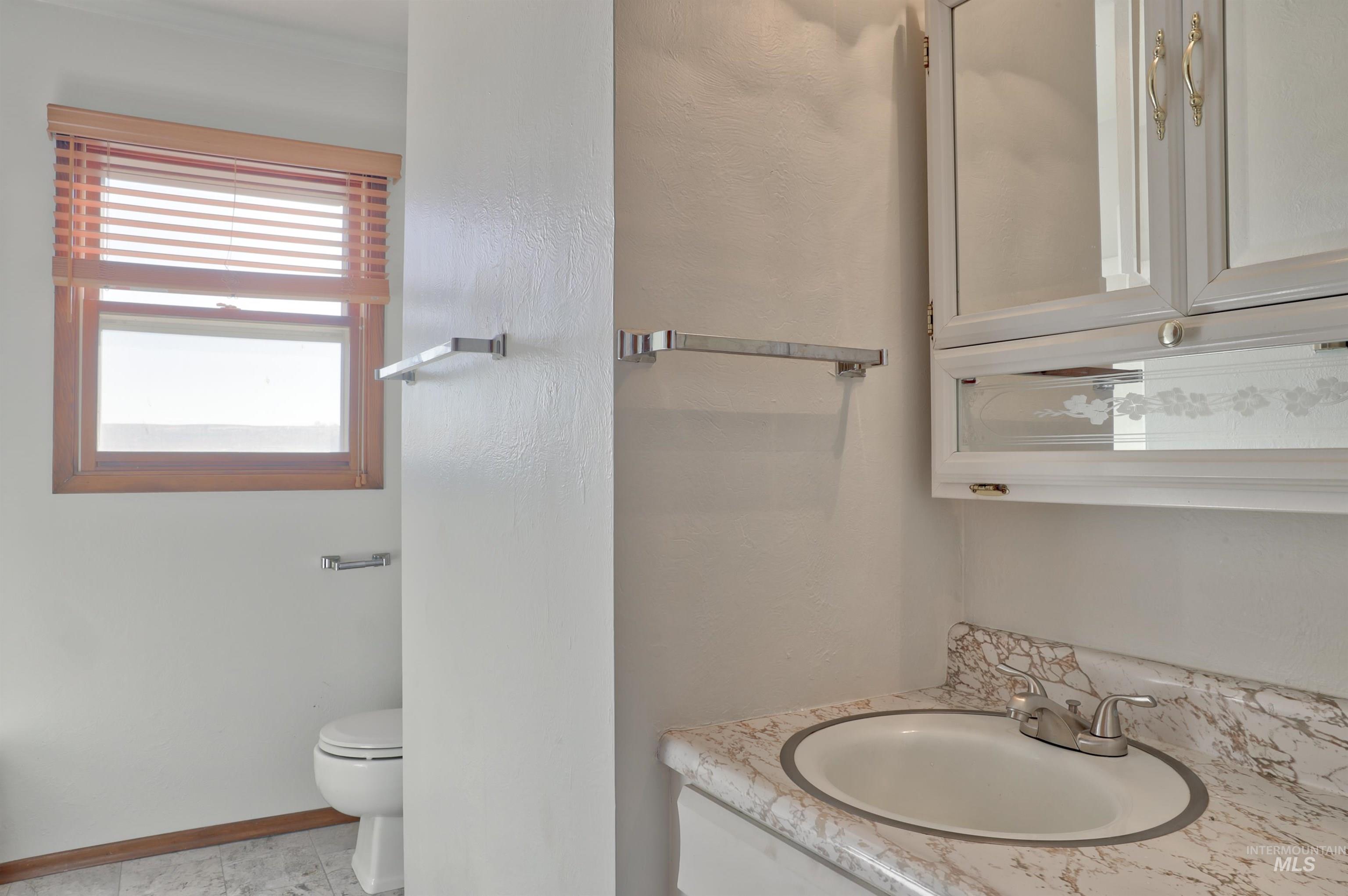 Half bathroom featuring vanity and toilet