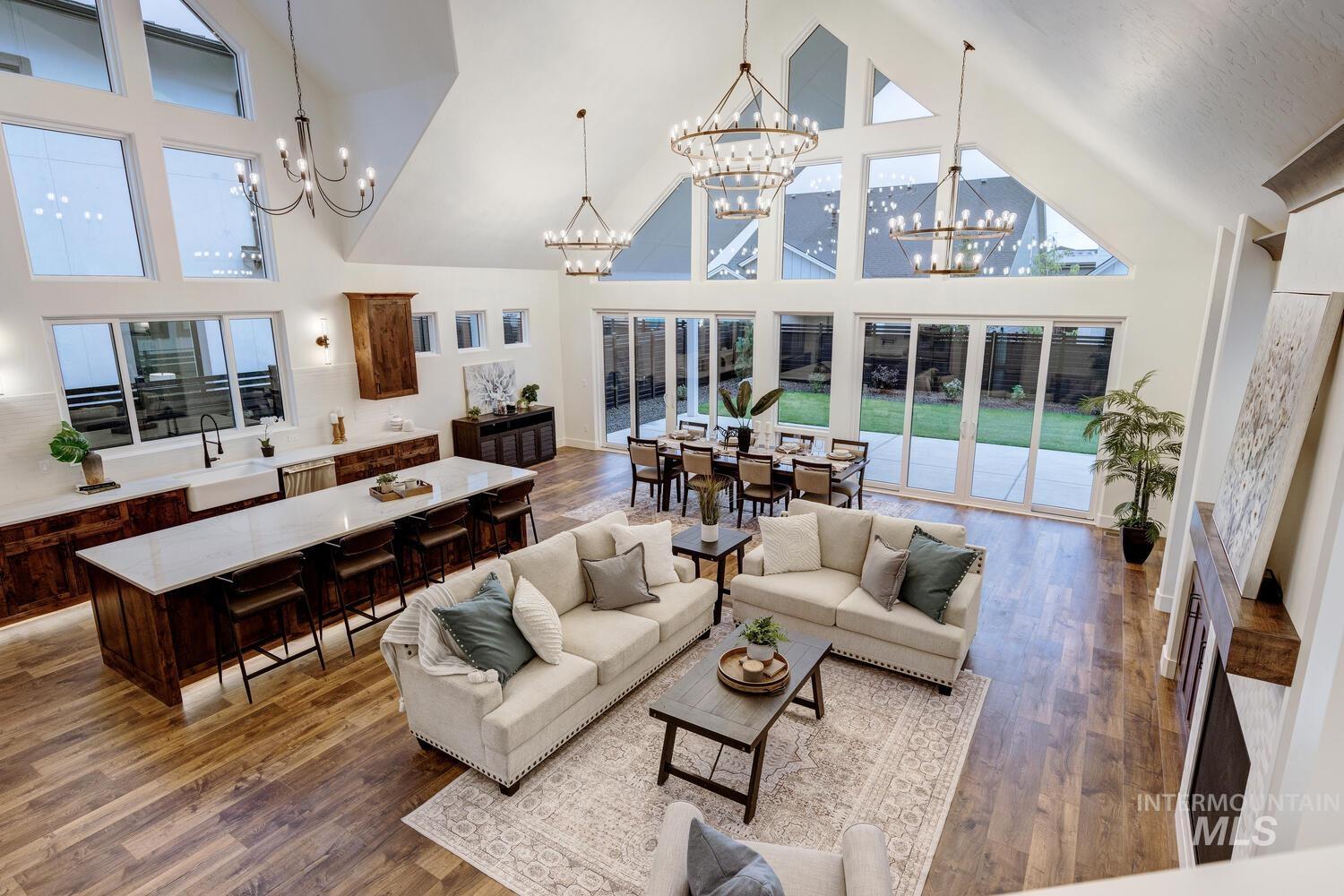 Living room featuring high vaulted ceiling, dark wood-type flooring, and a chandelier