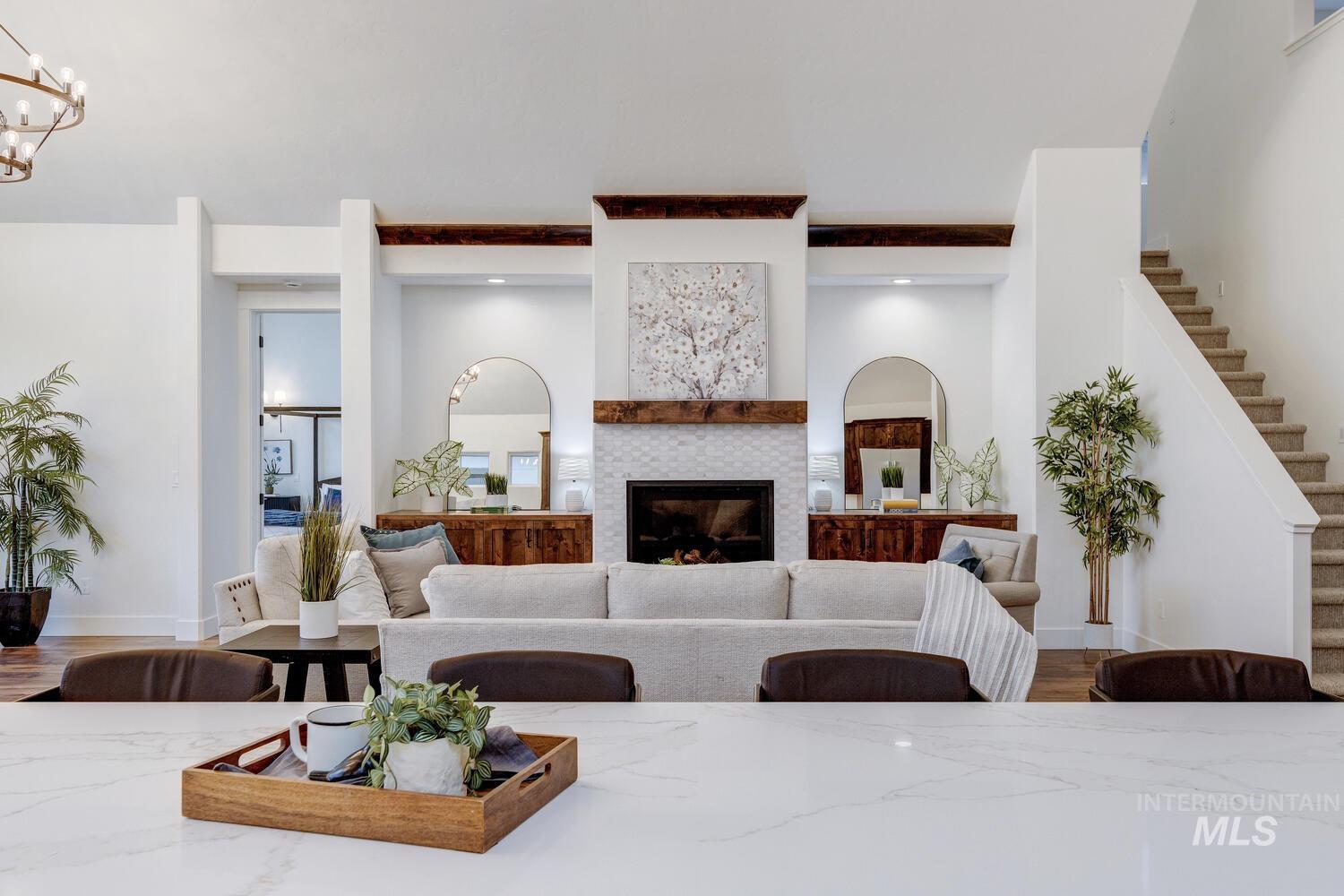 Living room featuring wood finished floors, a tile fireplace, and stairway