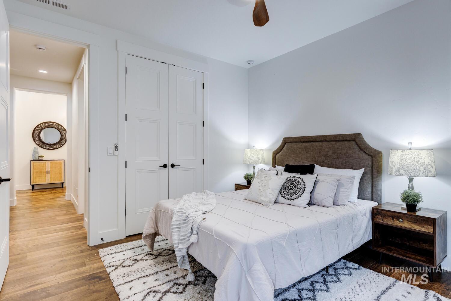 Bedroom with wood finished floors, a closet, and ceiling fan