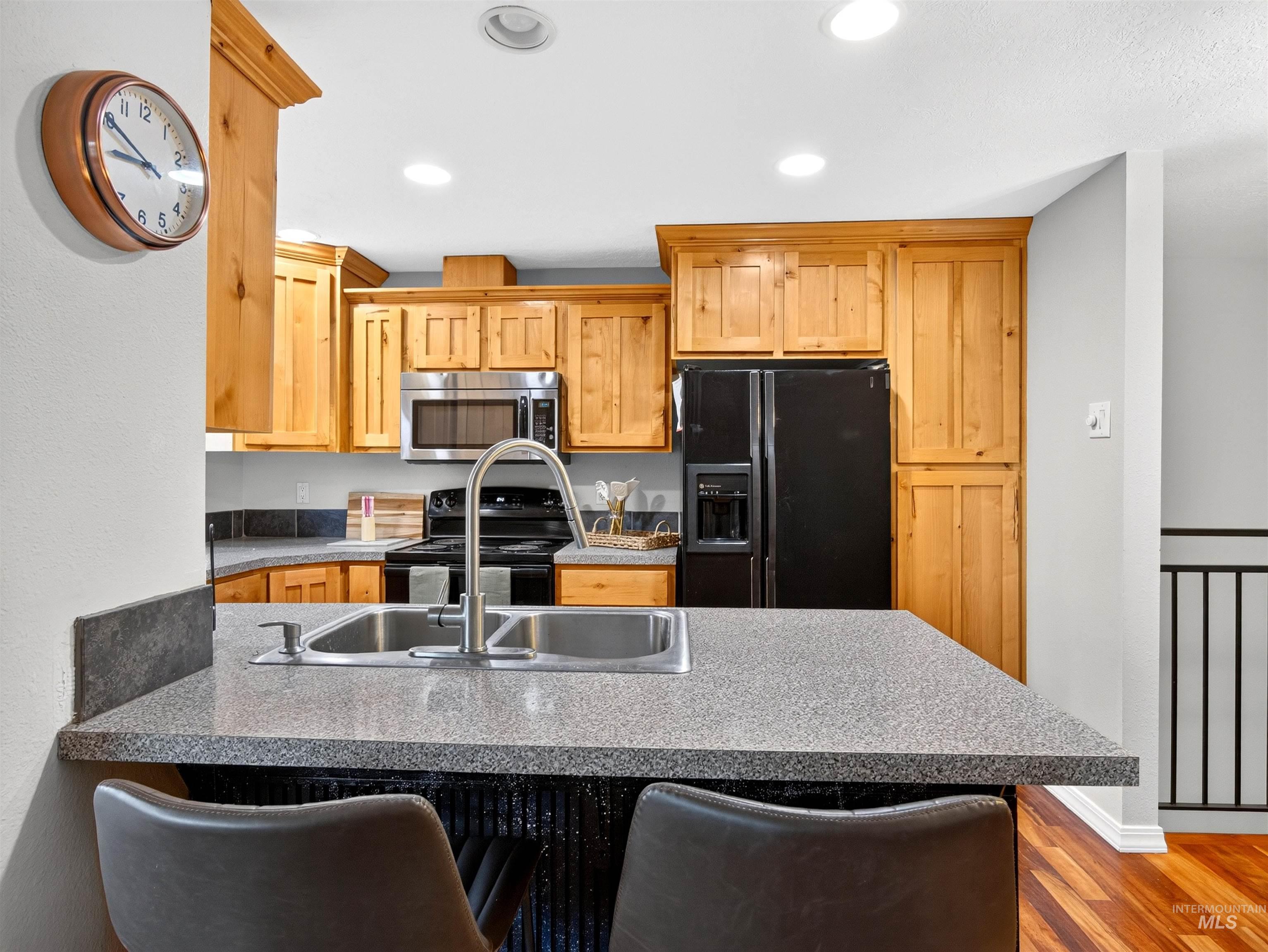 Kitchen featuring a breakfast bar with a stainless steel sink and gooseneck faucet