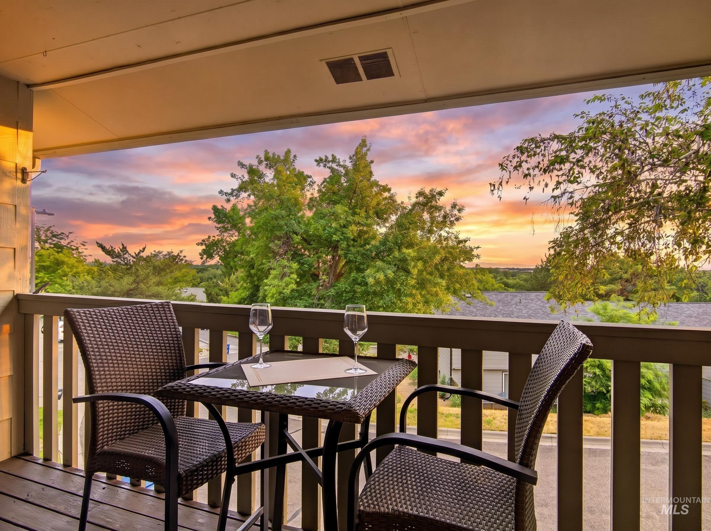Private outdoor balcony featuring wood decking, a painted railing, and an overhead ceiling