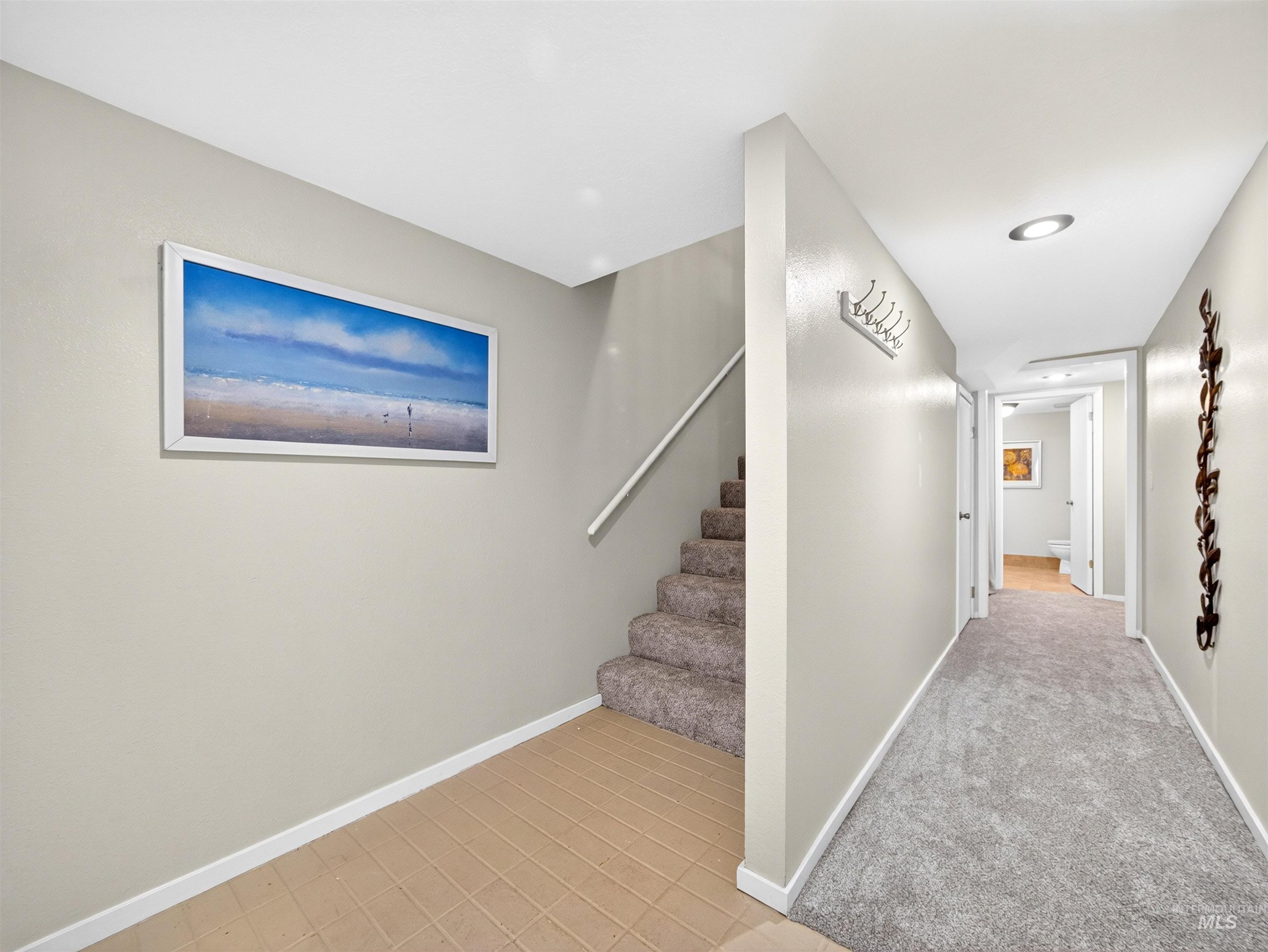 Entryway featuring a combination of tiled flooring and plush carpeting