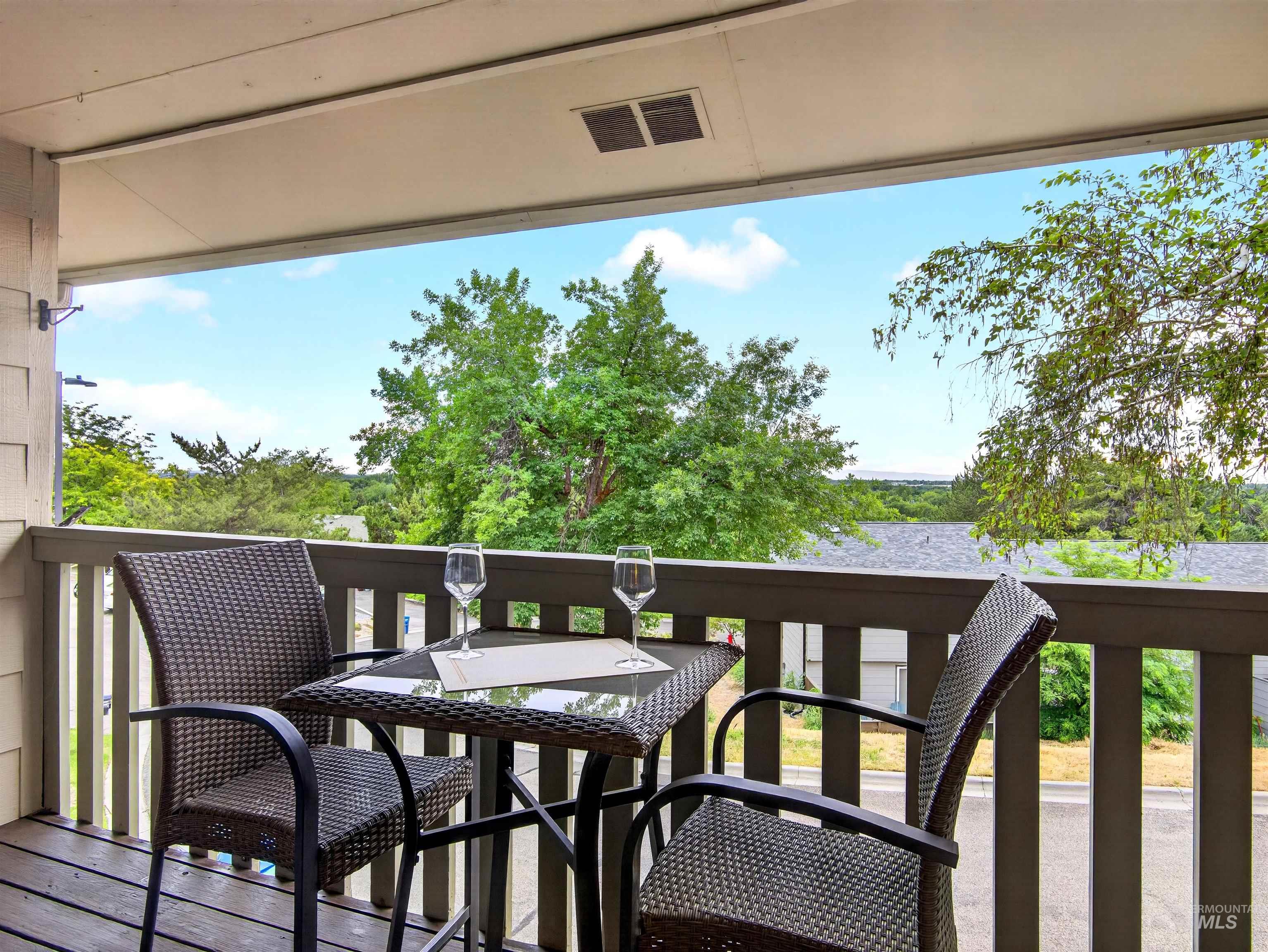 Private balcony with wood-finish flooring and painted railing