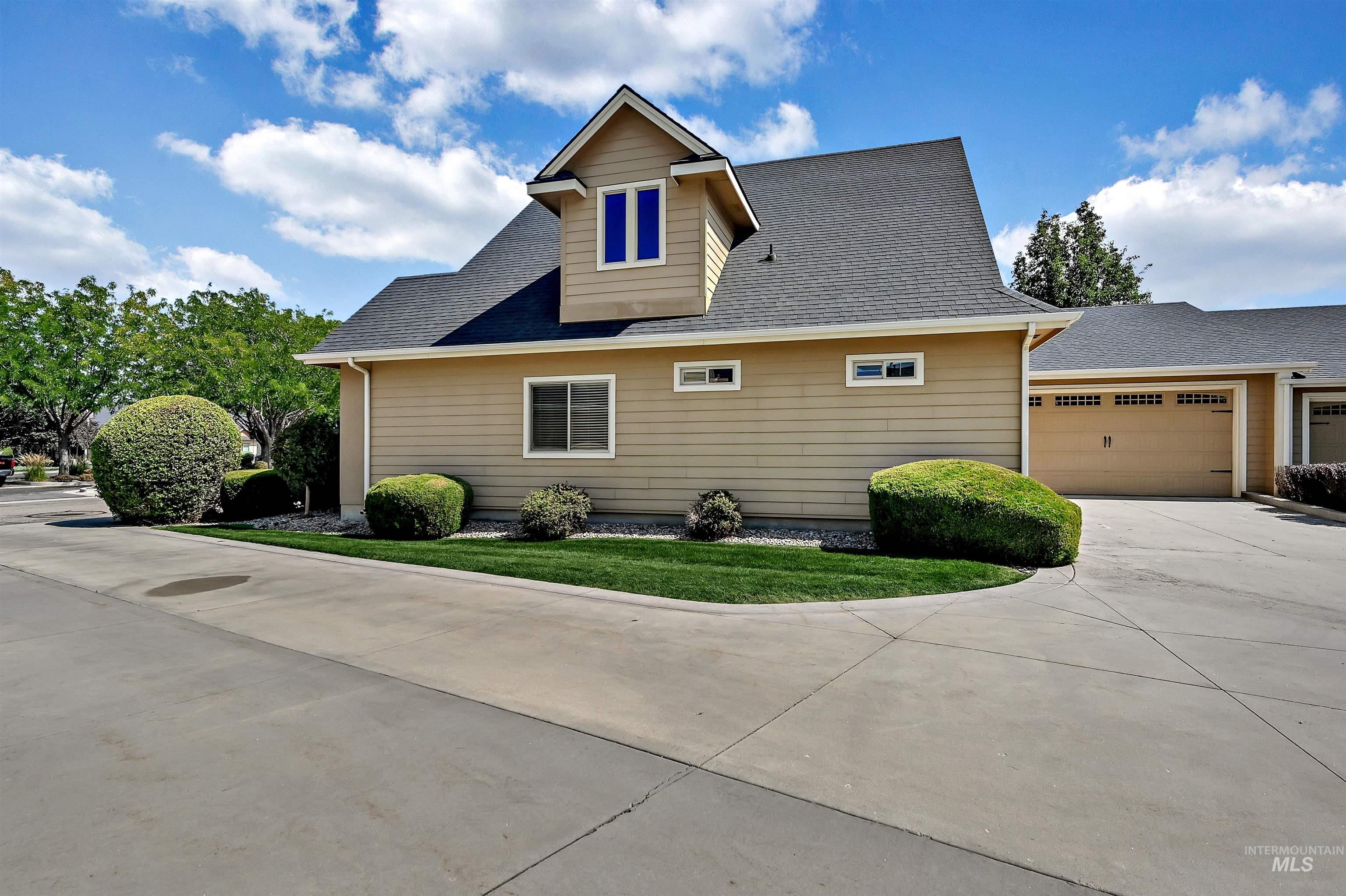 View of property exterior with roof with shingles, driveway, and a garage