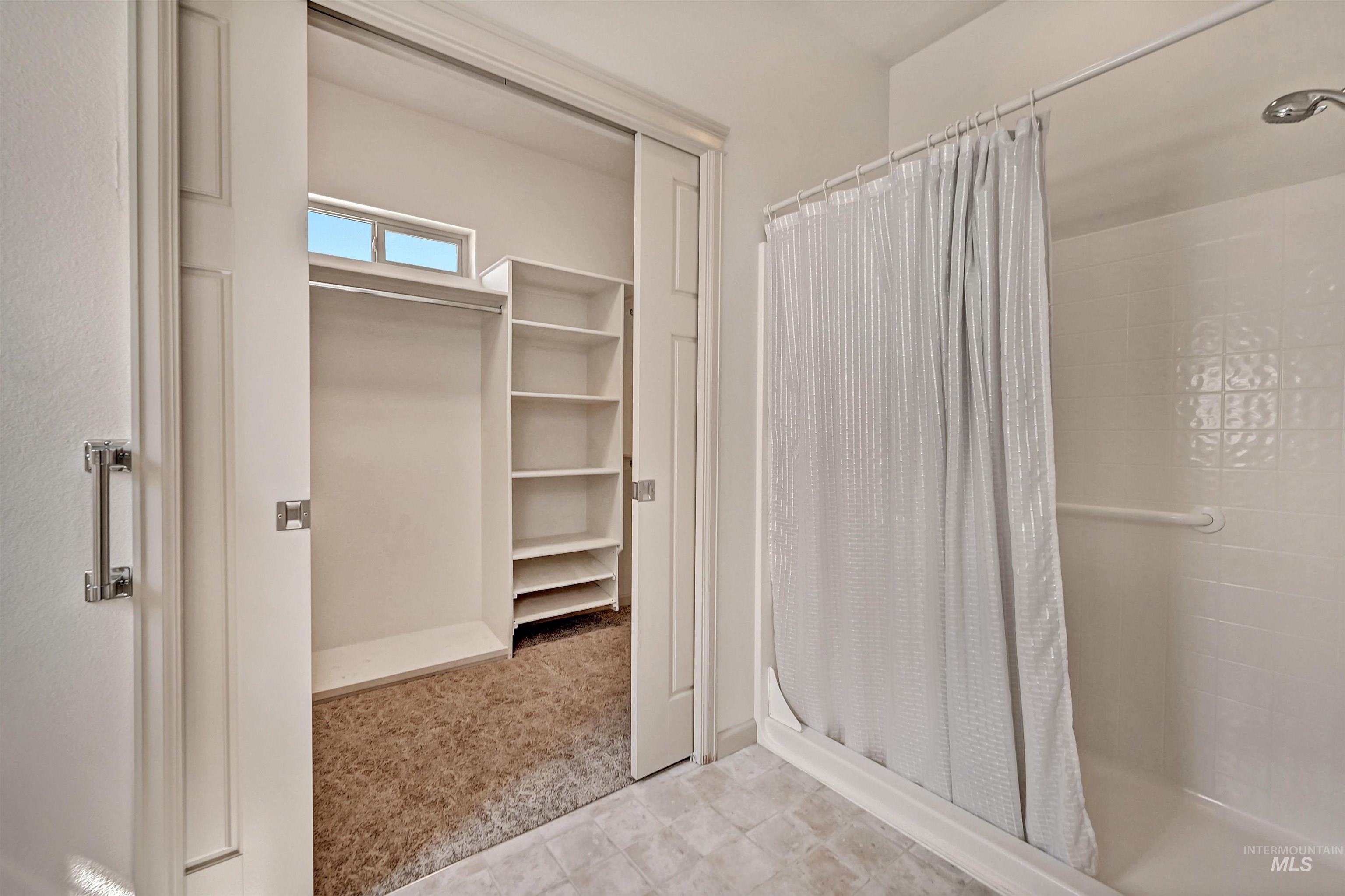 Bathroom featuring a stall shower and a spacious closet