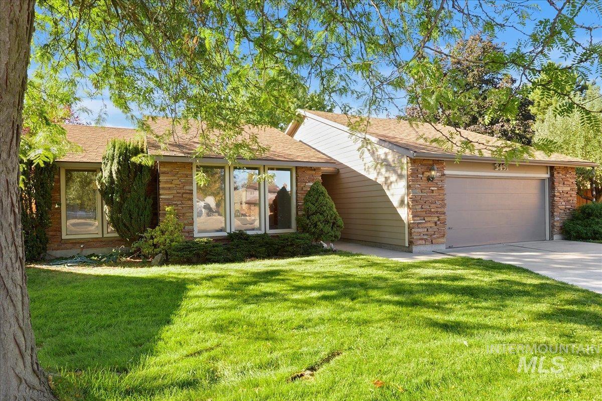Single story home with a garage, a front lawn, roof with shingles, concrete driveway, and stone siding