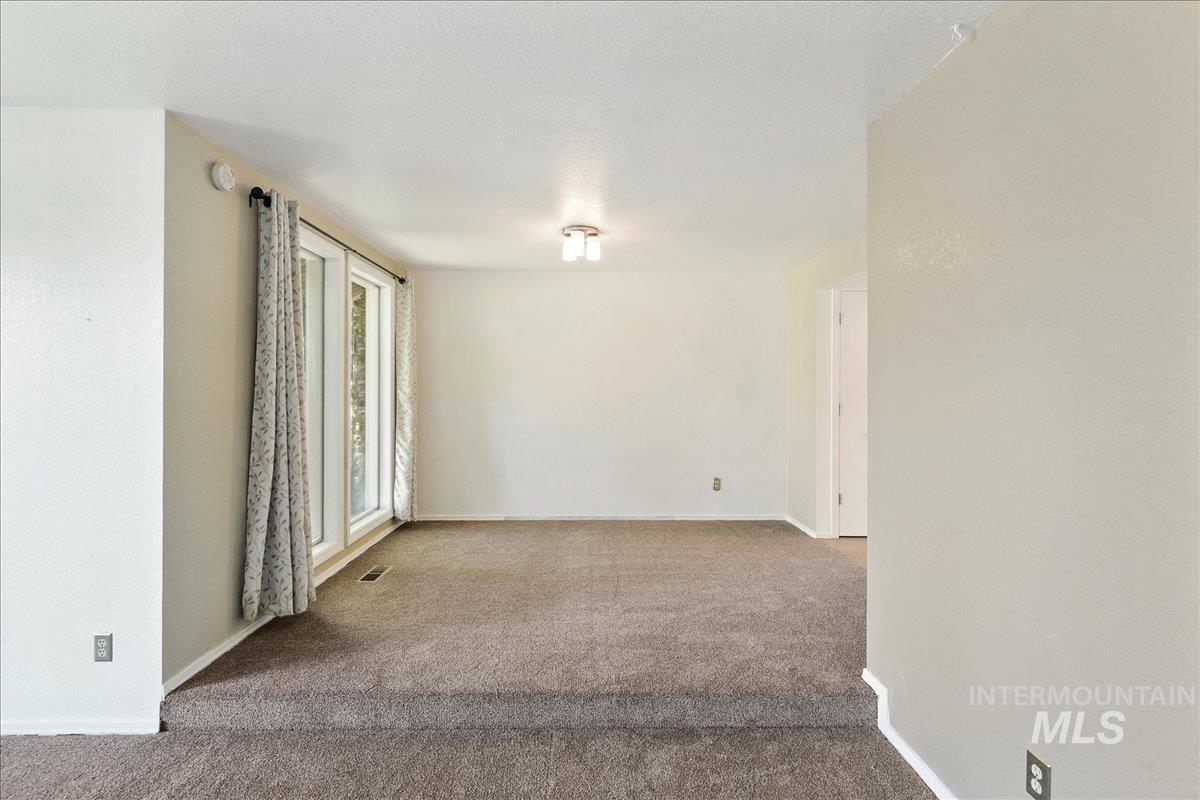 Carpeted empty room with baseboards and a textured ceiling