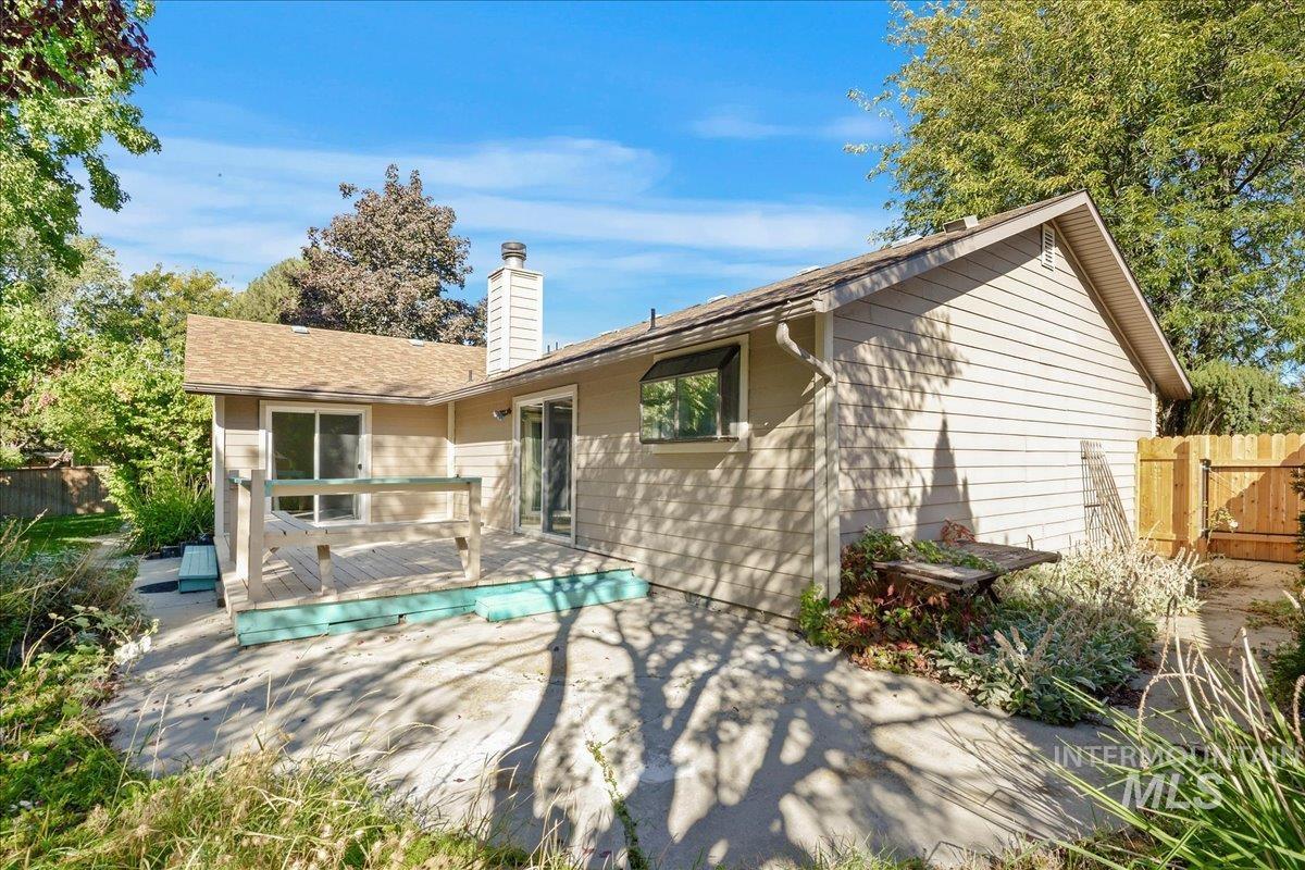 Back of property with a chimney and a wooden deck