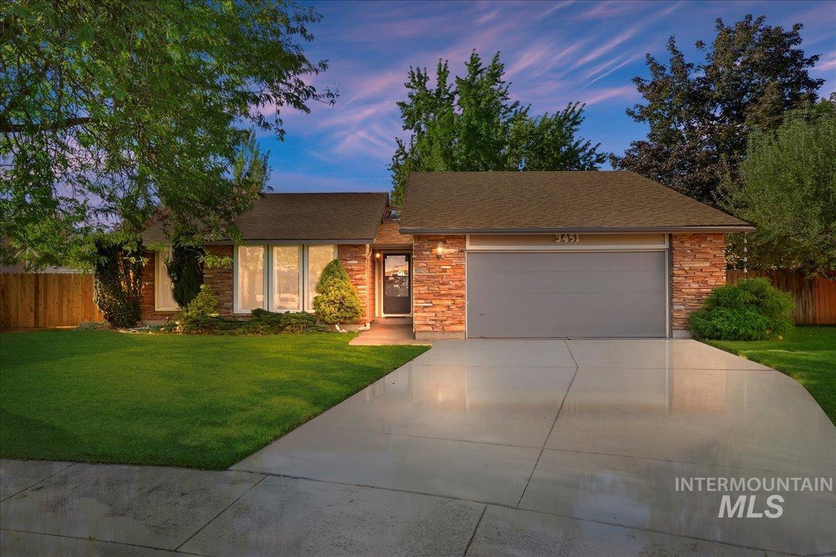 View of front of home with a shingled roof, concrete driveway, an attached garage, and brick siding