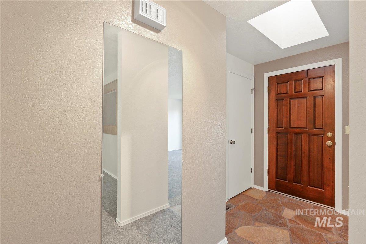 Foyer featuring a skylight and a textured wall