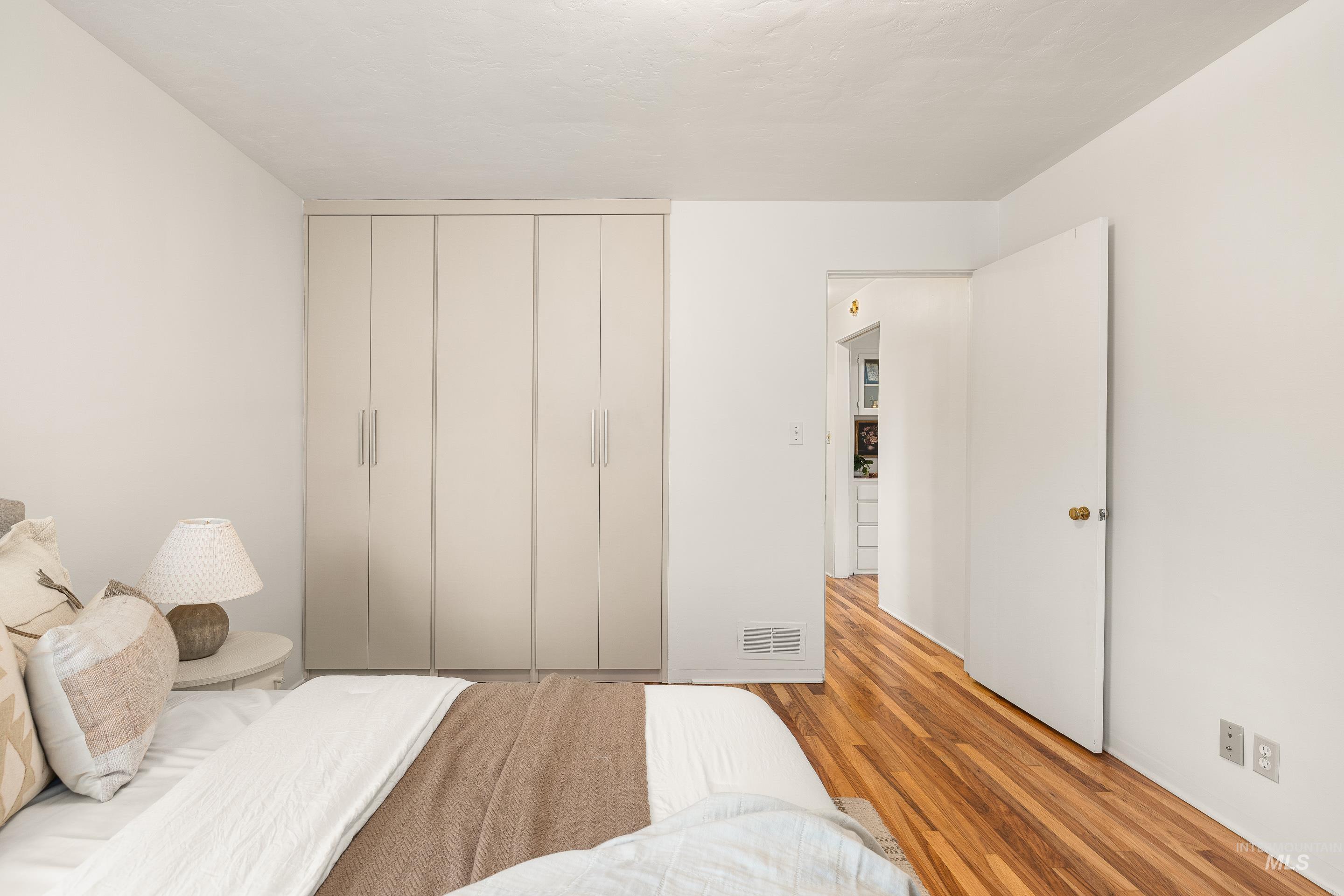 Bedroom with wood finished floors and a closet