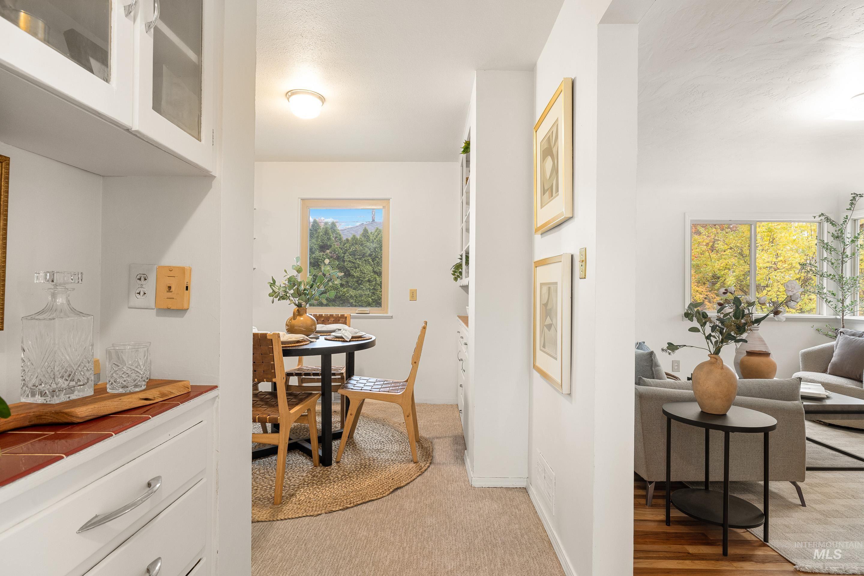 Hallway with baseboards and light carpet