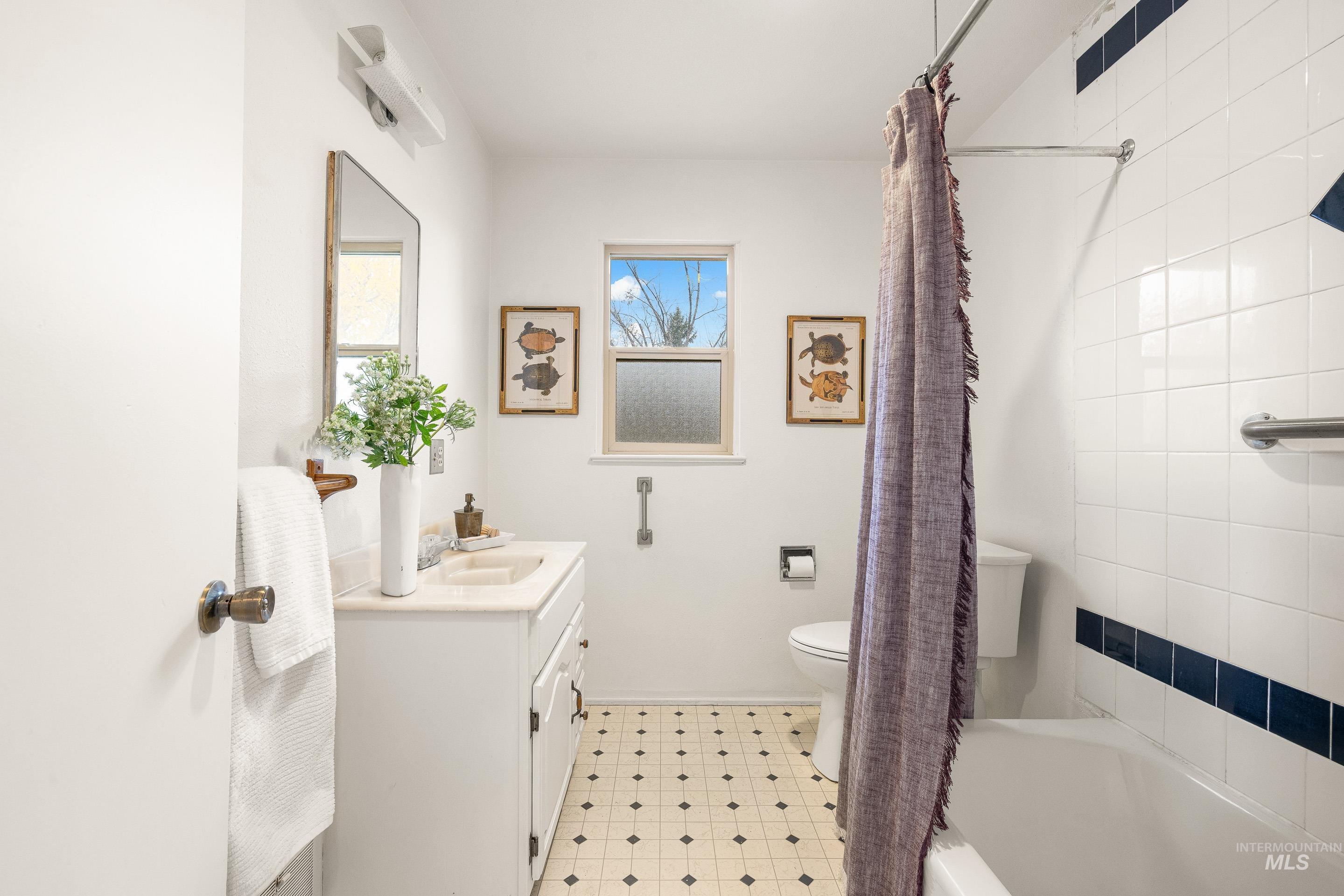 Full bath featuring vanity and shower / bath combo with shower curtain